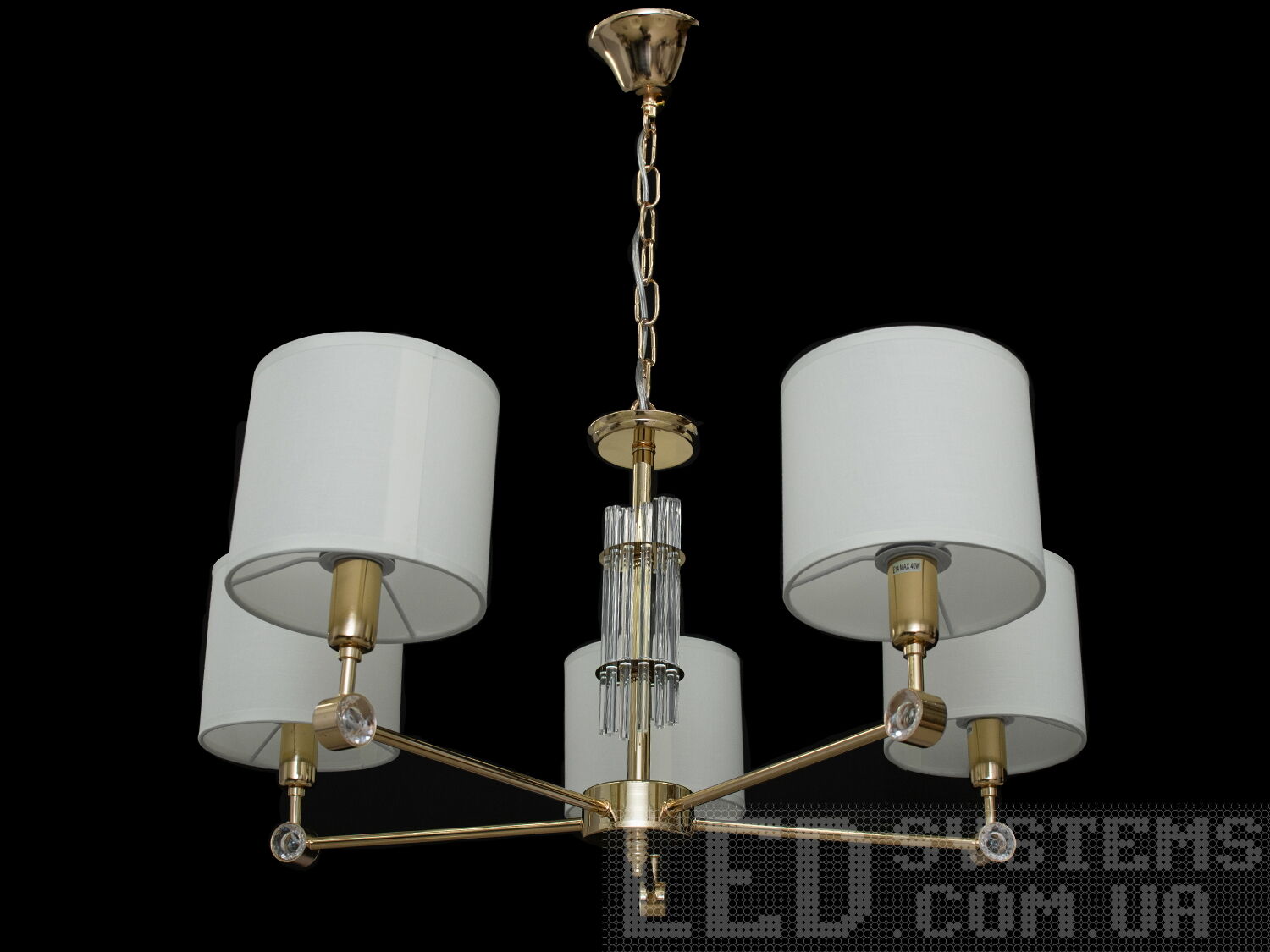 Люстра з абажурами на 5 ламп у стилі сучасна класика з витонченою металевою основою та стильними кришталевими елементами. Ви можете вибирати виконання металевих частин у золотому або хромованому варіанті. Застосовується для вітальні, залу, холу, спальні. У цій серії люстр і бра ідеально переплелися такі поняття, як солідність, строгість і простота.
Люстри та бра цієї моделі під звичайні лампи розжарювання або &laquo;LED-економки&raquo; на патрон Е14 внесуть класичні нотки до Вашого інтер'єру та дозволять підібрати потрібну вам температуру світіння.Універсальним кріпленням на планку легко кріпляться на будь-який тип стелі (підвісний, натяжний, звичайний). Увімкнення/вимкнення відбувається з настінного вимикача.