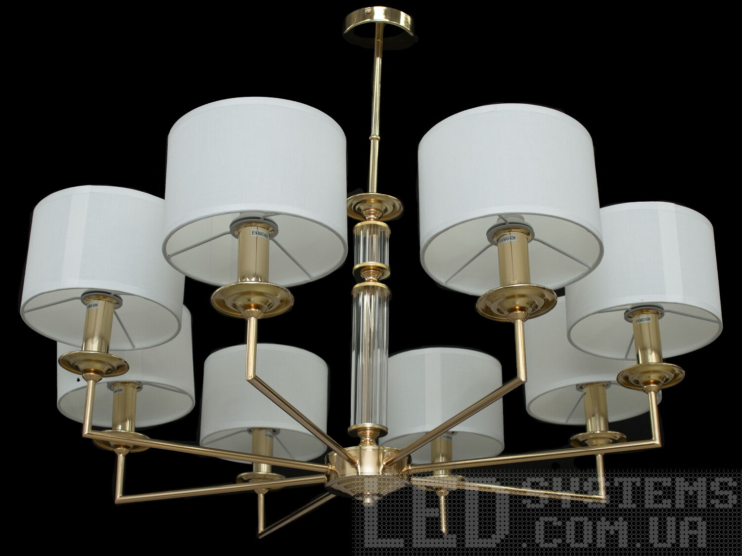 Елегантна люстра з абажурами на 8 ламп для вітальні, з витонченою металевою основою та стильними кришталевими елементами. Застосовується для вітальні, залу, холу, спальні. У цій серії люстр і бра ідеально переплелися такі поняття, як солідність, строгість і простота.
Люстри та бра цієї моделі під звичайні лампи розжарювання або &laquo;LED-економки&raquo; на патрон Е14 внесуть класичні нотки до Вашого інтер'єру та дозволять підібрати потрібну вам температуру світіння.Універсальним кріпленням на планку легко кріпляться на будь-який тип стелі (підвісний, натяжний, звичайний). Увімкнення/вимкнення відбувається з настінного вимикача.