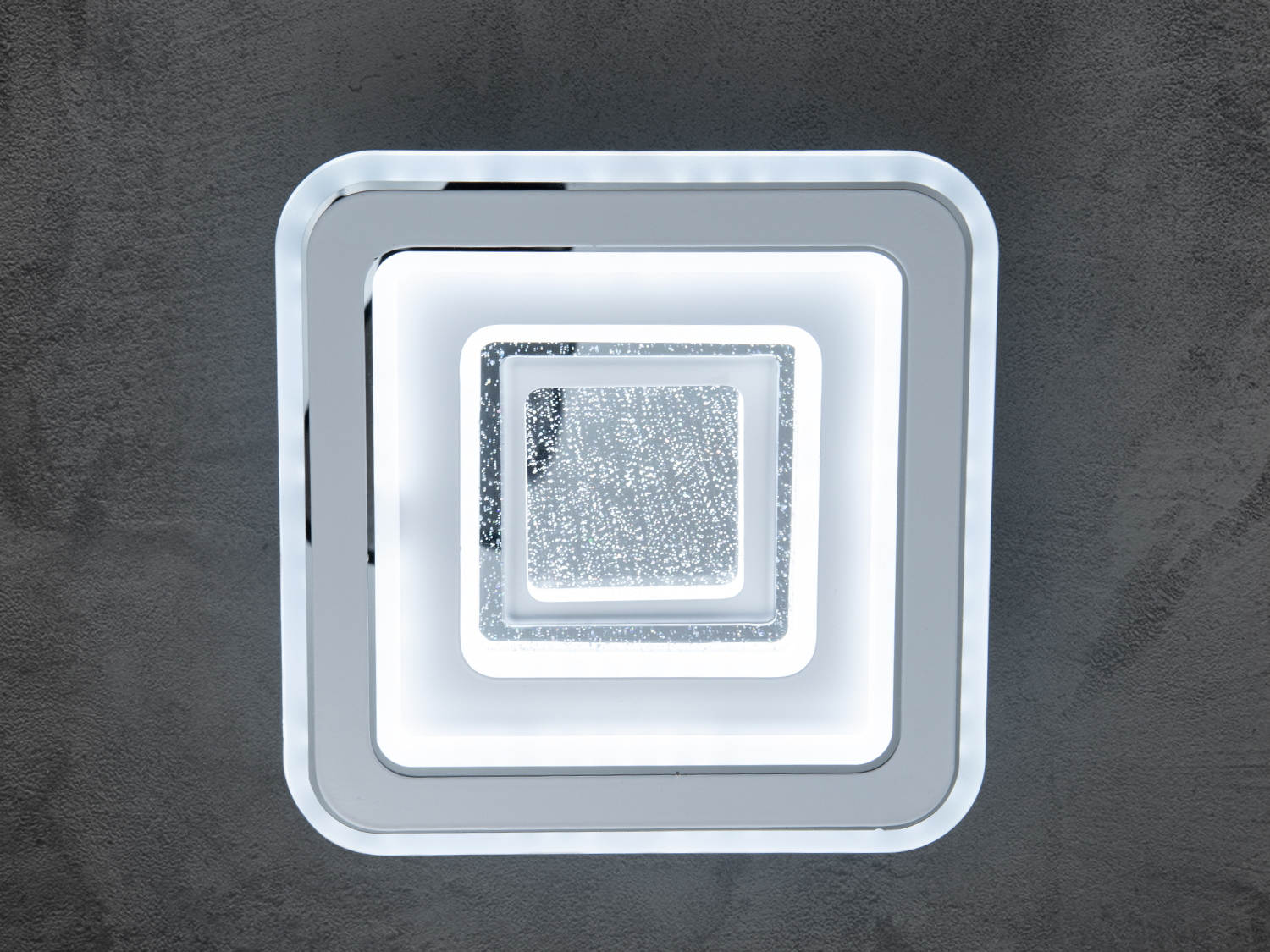 Квадратний світлодіодний світильник у ванну з унікальним багатошаровим дизайном чудово впишеться в інтер'єри в стилі хай-тек або мінімалізм, додавши елегантності та динаміки вашому простору. Вбудовані світлодіоди забезпечують рівномірне та м'яке освітлення, що робить його ідеальним вибором для віталень, спалень або офісів.
Універсальність проявляється в способах застосування: як стельовий люстр, настінні світильники, накладні точкові світильники.
Використання як накладний точковий світильник відкриває безліч можливостей для креативного освітлення простору. Він може освітлювати картини, акцентуючи на деталях і кольорах, або створювати фокус на обраній зоні, наприклад, над книжковою полицею або робочим столом.
Світильник має три режими теплий 3200К, нейтральний 4100К, холодний 6000К, який перемикаються увімкненням/вимкненням із настінного вимикача. Усередині передбачене використання світлодіодів, що забезпечує енергоощадження й довговічність.
Ці світильники просто адаптуються до різних інтер'єрних стилів, від мінімалізму до максималізму, завдяки своїм незаплямованим лініям і нейтральним кольорам. Як світильник можна легко інтегрувати в будь-який дизайн інтер'єру завдяки своїй простій, але елегантній формі. Він стане центральним елементом освітлення й прикрасою простору.
Кріпляться до стелі будь-якого типу універсальним кріпленням на монтажну планку.