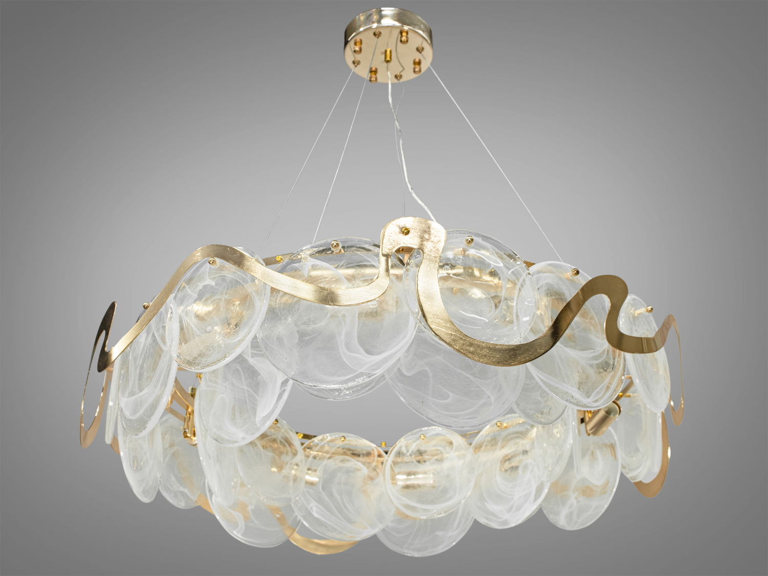 Підвісна скляна люстра для вітальні з круглими елементами на 10 ламп, з металевим корпусом добре виглядатиме в сучасному інтер'єрі зали, спальні, коридору або кухні. На неї можна дивитися під будь-яким кутом, і не дивлячись на легкість конструкції люстри, ви завжди бачитимете лампи тільки через димчасте скло. Висота люстри регулюється завдяки чому підходить для низьких стель.
Люстра-підвіс під звичайні лампочки розжарювання, економки або світлодіодні лампи з цоколем Е14. Стельове кріплення на планку універсальне та підходить для підвісних, натяжних та звичайних стель.
Увага. Вага люстри 12кг.
Лампи до комплекту не входять.