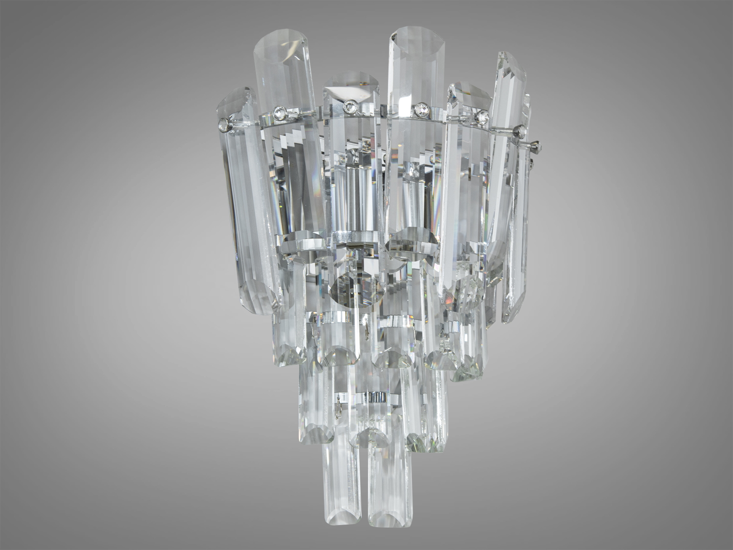 Сучасний кришталевий світильник бра призначений для стильного сучасного або класичного інтер'єру. Враховуючи потреби сучасного освітлення, світильник розрахований на дві лампи Е14. Бра освітлює простір м'яким, але водночас яскравим світлом, що ідеально підходить для створення затишної атмосфери в кімнаті. Така універсальність дозволяє використовувати його як у маленьких кімнатах, так і просторих зонах.
З основою хромованого кольору, що сяє під кожним кутом, світильник стає справжньою окрасою будь-якого інтер'єру.
Кріпиться до будь-якого типу стінних поверхонь універсальним кріпленням на планку.
Лампи до комплекту не входять.