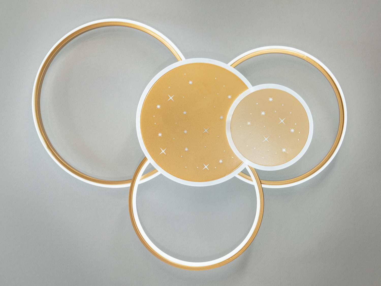 Світлодіодна люстра у вітальню з пультом – це втілення елегантності та сучасного дизайну, натхненого небесними орбітами та гармонією сфер. Її витончена форма представлена ​​золотистими колами, що перетинаються, які створюють ефект легкості і невагомості.