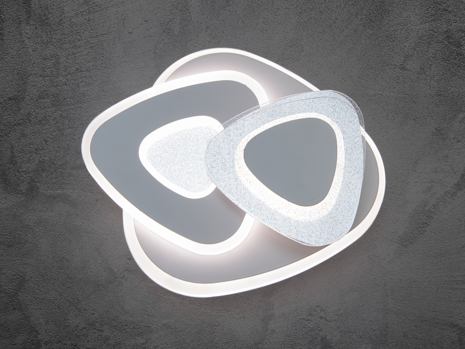 Світлодіодний смарт-світильник у ванну є зразком багатофункціональності й інновації дизайну. Унікальність цього світильника починається з його дизайну: чіткі геометричні лінії та м′які розсіювачі виготовлені з литого акрилу, які надають йому вишуканої простоти й елегантності, а також полягає в можливості використовувати цей світильник як настінні світильники, так і у формі накладних точкових світильників або стельових люстр.
Універсальність проявляється в способах застосування: як настінні світильники, накладні точкові світильники та стельові люстри.
Використання як накладний точковий світильник відкриває безліч можливостей для креативного освітлення простору. Він може освітлювати картини, акцентуючи на деталях і кольорах, або створювати фокус на обраній зоні, наприклад, над книжковою полицею або робочим столом.
Як стельовий світильник, цей світильник може стати центральним елементом в інтер′єрі ванної, коридору або передпокою, кухні або зали.
Ці світильники просто адаптуються до різних інтер′єрних стилів, від мінімалізму до максималізму, завдяки своїм незаплямованим лініям і нейтральним кольорам. Як світильник можна легко інтегрувати в будь-який дизайн інтер′єру завдяки своїй простій, але елегантній формі. Він стане центральним елементом освітлення й прикрасою простору.
Кріпляться до стелі будь-якого типу універсальним кріпленням на монтажну планку.