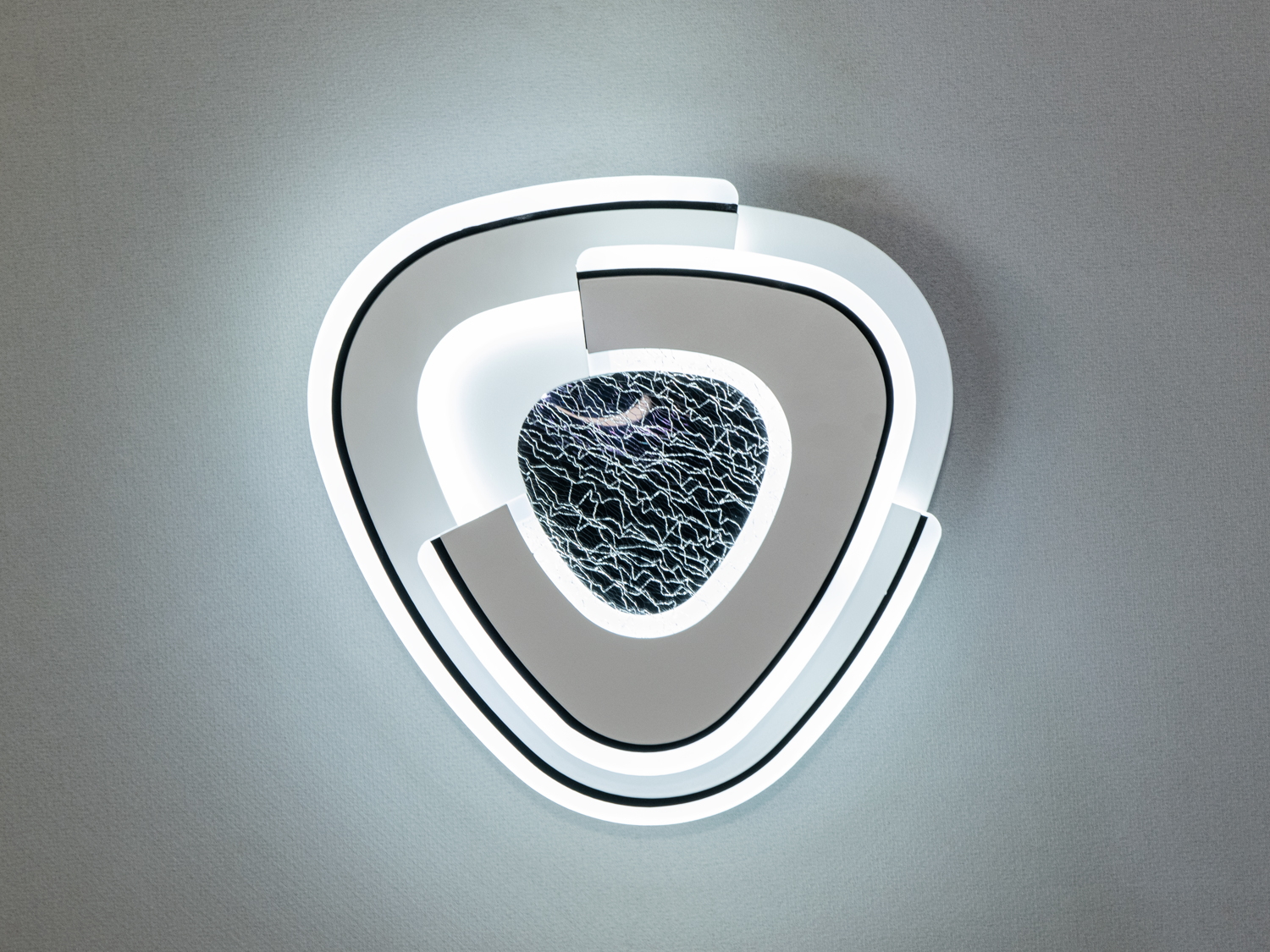 Світлодіодний настінний світильник з трикутним дизайном і текстурованою центральною частиною для затишного освітлення.