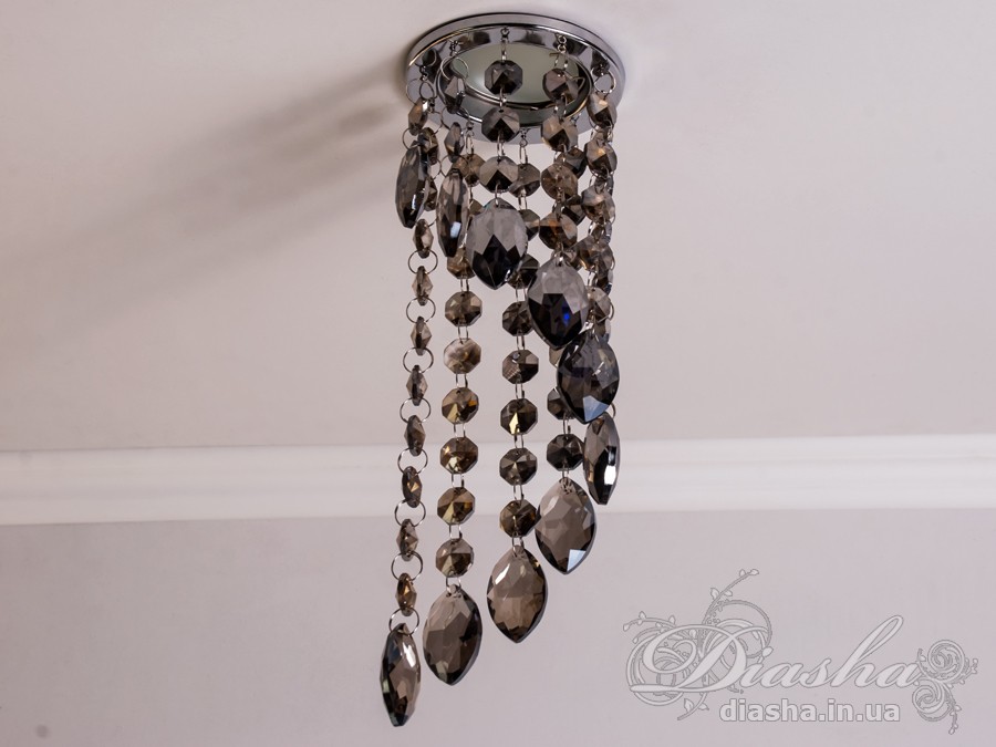 Цей розкішний врізний точковий світильник з кришталевими підвісами від ТМ &laquo;Діаша&raquo; віддзеркалює розкіш і вишуканість, пропонуючи більше ніж просте освітлення &ndash; він вносить елементи мистецтва та елегантності в інтер'єр. Ця унікальна освітлювальна прикраса втілює бездоганний баланс між функціональністю та дизайном, привносячи в будь-яку кімнату ауру ексклюзивності та стилю.
Кожен кришталь, відшліфований до досконалості, створює гіпнотичний ефект, м'яко відбиваючи світло та розкидаючи його по кімнаті у вигляді динамічного візерунка іскринок. Кришталі підвішені на тонких, ледве помітних нитках, ніби парять у повітрі, зачаровуючи своєю грацією та легкістю. Вони перетворюють кожен випадковий промінь світла в святковий феєрверк, наповнюючи простір теплим світінням та витонченою атмосферою.
Цей світильник ідеально підходить для вітальні, де він може стати яскравим акцентом та центром уваги, допомагаючи створити атмосферу розкоші та комфорту для прийому гостей. У кухні він додасть сяйва та благородства, підсилюючи апетитність страв та красу приготування. У спальні, врізний точковий світильник з кришталевими підвісами забезпечить м'яке та заспокійливе освітлення, створюючи ідеальне середовище для відпочинку та релаксації.
У громадських просторах, таких як кафе, світильник створить особливу, неповторну атмосферу, де кожен промінь світла виграє в кришталях, додаючи інтер'єру вишуканості та шарму. Придбати цей світильник можна недорого, що робить його доступним вибором для тих, хто бажає додати елементи розкоші в свій простір без зайвих витрат.
Стилістика світильника притаманна багатьом дизайнерським напрямкам: від класичного і ретро до сучасного мінімалізму та індустріального шику. Він уособлює в собі естетику, яка перевершує тренди, залишаючись актуальною та елегантною в будь-якій епосі.