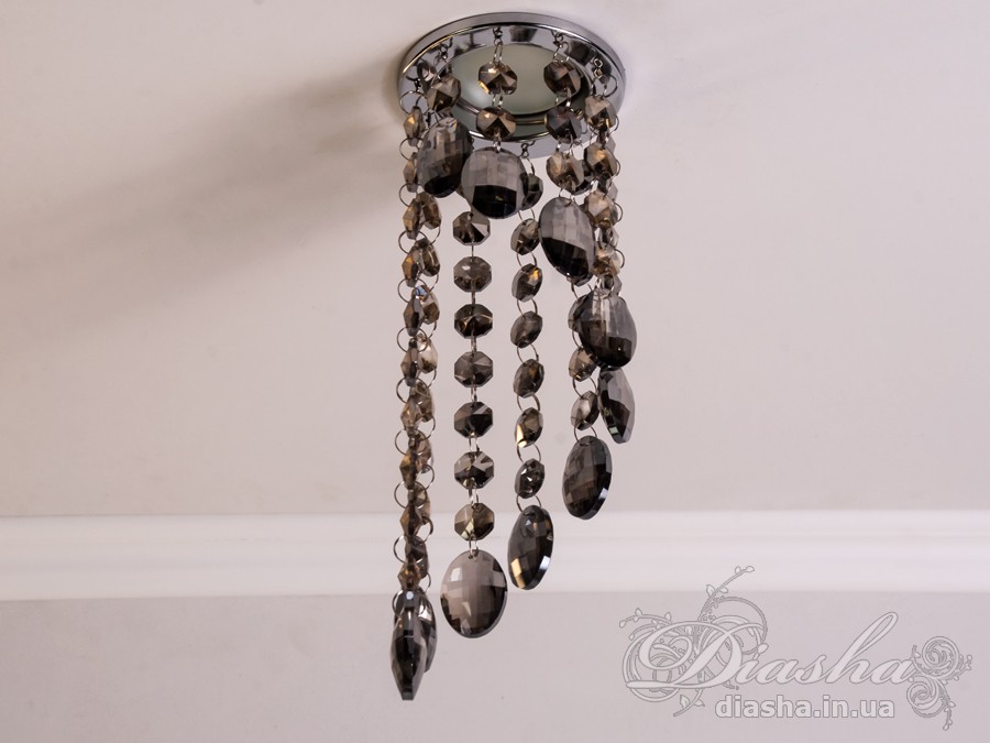 Врізний точковий світильник з кришталевими підвісами являє собою витончене освітлювальне рішення, яке здатне додати розкоші та величі будь-якому простору. Він демонструє багатство інтер'єрних можливостей, відбиваючи найтонші нюанси сучасного дизайну і при цьому підтримуючи класичну естетику.
Центральна частина світильника виконана з міцного металу, фініш якого імітує золото, додаючи елемент розкішного благородства. Від цієї центральної частини спускаються елегантні кришталеві підвіси, кожен з яких є маленьким витвором мистецтва. Криштали мають різноманітні грані, що ловлять світло і переломлюють його в блискучий калейдоскоп, створюючи чарівні ігри світла по всьому приміщенню.
Такий світильник стане чудовим доповненням до інтер'єру залу, де він може бути використаний для створення затишної атмосфери чи служити як основний акцент оформлення. У кухні він може допомогти виділити зону їдальні або підкреслити красу кухонних меблів. В спальні світильник забезпечить м'яке і романтичне освітлення, створюючи ідеальну атмосферу для відпочинку і релаксації.
У просторах кафе та інших громадських місць цей світильник зможе додати нотки ексклюзивності та статусу. Його кришталеві підвіси можуть служити не лише джерелом світла, а й елементом декору, що приваблює погляди і запам'ятовується відвідувачам.
Такий світильник легко можна придбати за доступною ціною, що робить його відмінним вибором для тих, хто прагне купити дешево точковий світильник, але не хоче жертвувати якістю та виглядом. Світильник від ТМ &laquo;Діаша&raquo; поєднує в собі стильність, елегантність та сучасну технологічність, будучи притаманним багатьом стилям від класики до модерну.
Врізний точковий світильник з кришталевими підвісами не просто освітлює простір - він перетворює його, додаючи кожному моменту особливу красу та чарівність, які лише кришталь здатний створити.
