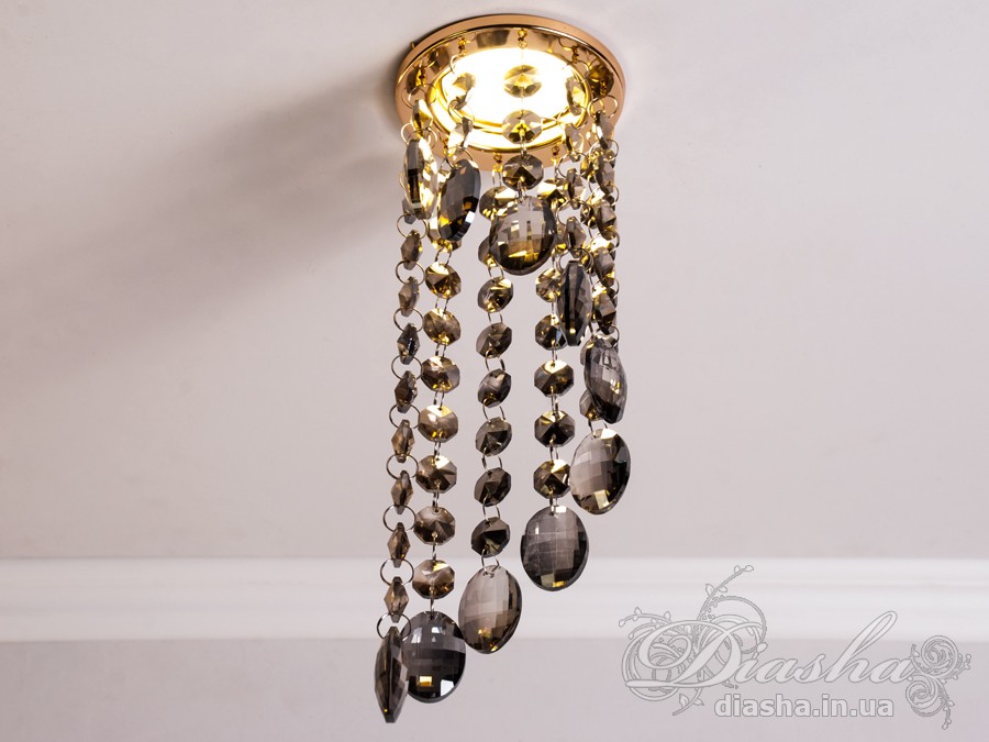 Цей розкішний врізний точковий світильник з кришталевими підвісами від ТМ &laquo;Діаша&raquo; віддзеркалює розкіш і вишуканість, пропонуючи більше ніж просте освітлення &ndash; він вносить елементи мистецтва та елегантності в інтер'єр. Ця унікальна освітлювальна прикраса втілює бездоганний баланс між функціональністю та дизайном, привносячи в будь-яку кімнату ауру ексклюзивності та стилю.
Кожен кришталь, відшліфований до досконалості, створює гіпнотичний ефект, м'яко відбиваючи світло та розкидаючи його по кімнаті у вигляді динамічного візерунка іскринок. Кришталі підвішені на тонких, ледве помітних нитках, ніби парять у повітрі, зачаровуючи своєю грацією та легкістю. Вони перетворюють кожен випадковий промінь світла в святковий феєрверк, наповнюючи простір теплим світінням та витонченою атмосферою.
Цей світильник ідеально підходить для вітальні, де він може стати яскравим акцентом та центром уваги, допомагаючи створити атмосферу розкоші та комфорту для прийому гостей. У кухні він додасть сяйва та благородства, підсилюючи апетитність страв та красу приготування. У спальні, врізний точковий світильник з кришталевими підвісами забезпечить м'яке та заспокійливе освітлення, створюючи ідеальне середовище для відпочинку та релаксації.
У громадських просторах, таких як кафе, світильник створить особливу, неповторну атмосферу, де кожен промінь світла виграє в кришталях, додаючи інтер'єру вишуканості та шарму. Придбати цей світильник можна недорого, що робить його доступним вибором для тих, хто бажає додати елементи розкоші в свій простір без зайвих витрат.
Стилістика світильника притаманна багатьом дизайнерським напрямкам: від класичного і ретро до сучасного мінімалізму та індустріального шику. Він уособлює в собі естетику, яка перевершує тренди, залишаючись актуальною та елегантною в будь-якій епосі.