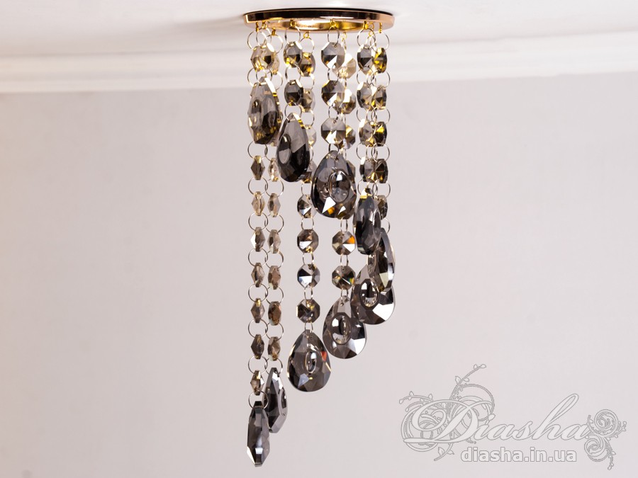 Врізний точковий світильник з кришталевими підвісами являє собою витончене освітлювальне рішення, яке здатне додати розкоші та величі будь-якому простору. Він демонструє багатство інтер'єрних можливостей, відбиваючи найтонші нюанси сучасного дизайну і при цьому підтримуючи класичну естетику.
Центральна частина світильника виконана з міцного металу, фініш якого імітує золото, додаючи елемент розкішного благородства. Від цієї центральної частини спускаються елегантні кришталеві підвіси, кожен з яких є маленьким витвором мистецтва. Криштали мають різноманітні грані, що ловлять світло і переломлюють його в блискучий калейдоскоп, створюючи чарівні ігри світла по всьому приміщенню.
Такий світильник стане чудовим доповненням до інтер'єру залу, де він може бути використаний для створення затишної атмосфери чи служити як основний акцент оформлення. У кухні він може допомогти виділити зону їдальні або підкреслити красу кухонних меблів. В спальні світильник забезпечить м'яке і романтичне освітлення, створюючи ідеальну атмосферу для відпочинку і релаксації.
У просторах кафе та інших громадських місць цей світильник зможе додати нотки ексклюзивності та статусу. Його кришталеві підвіси можуть служити не лише джерелом світла, а й елементом декору, що приваблює погляди і запам'ятовується відвідувачам.
Такий світильник легко можна придбати за доступною ціною, що робить його відмінним вибором для тих, хто прагне купити дешево точковий світильник, але не хоче жертвувати якістю та виглядом. Світильник від ТМ &laquo;Діаша&raquo; поєднує в собі стильність, елегантність та сучасну технологічність, будучи притаманним багатьом стилям від класики до модерну.
Врізний точковий світильник з кришталевими підвісами не просто освітлює простір - він перетворює його, додаючи кожному моменту особливу красу та чарівність, які лише кришталь здатний створити.