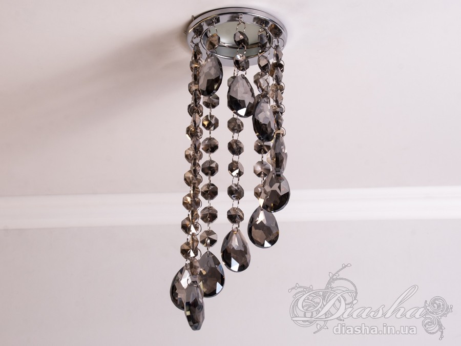 Цей розкішний врізний точковий світильник з кришталевими підвісами від ТМ &laquo;Діаша&raquo; віддзеркалює розкіш і вишуканість, пропонуючи більше ніж просте освітлення &ndash; він вносить елементи мистецтва та елегантності в інтер'єр. Ця унікальна освітлювальна прикраса втілює бездоганний баланс між функціональністю та дизайном, привносячи в будь-яку кімнату ауру ексклюзивності та стилю.
Кожен кришталь, відшліфований до досконалості, створює гіпнотичний ефект, м'яко відбиваючи світло та розкидаючи його по кімнаті у вигляді динамічного візерунка іскринок. Кришталі підвішені на тонких, ледве помітних нитках, ніби парять у повітрі, зачаровуючи своєю грацією та легкістю. Вони перетворюють кожен випадковий промінь світла в святковий феєрверк, наповнюючи простір теплим світінням та витонченою атмосферою.
Цей світильник ідеально підходить для вітальні, де він може стати яскравим акцентом та центром уваги, допомагаючи створити атмосферу розкоші та комфорту для прийому гостей. У кухні він додасть сяйва та благородства, підсилюючи апетитність страв та красу приготування. У спальні, врізний точковий світильник з кришталевими підвісами забезпечить м'яке та заспокійливе освітлення, створюючи ідеальне середовище для відпочинку та релаксації.
У громадських просторах, таких як кафе, світильник створить особливу, неповторну атмосферу, де кожен промінь світла виграє в кришталях, додаючи інтер'єру вишуканості та шарму. Придбати цей світильник можна недорого, що робить його доступним вибором для тих, хто бажає додати елементи розкоші в свій простір без зайвих витрат.
Стилістика світильника притаманна багатьом дизайнерським напрямкам: від класичного і ретро до сучасного мінімалізму та індустріального шику. Він уособлює в собі естетику, яка перевершує тренди, залишаючись актуальною та елегантною в будь-якій епосі.