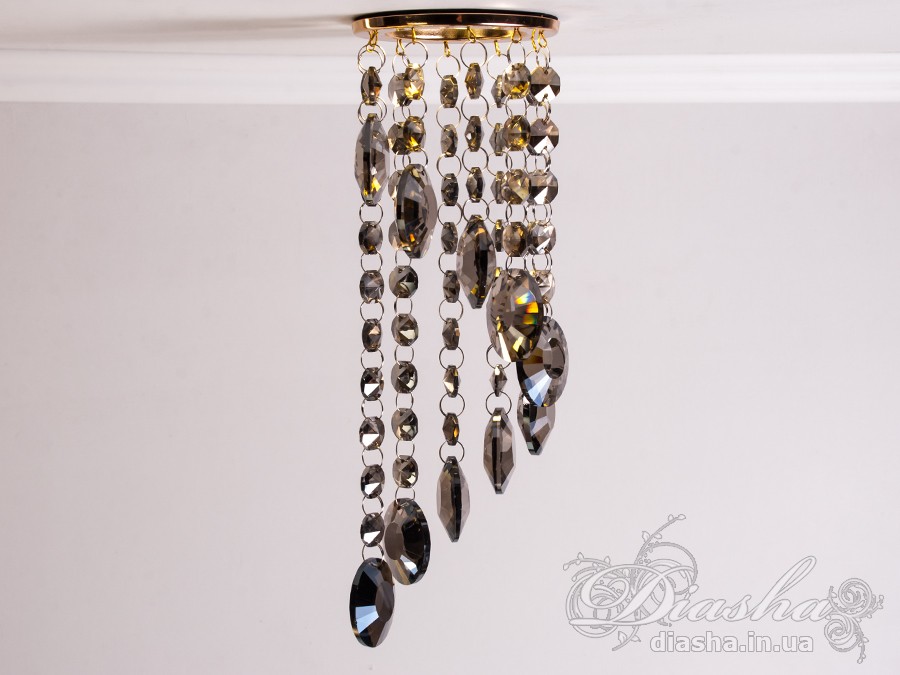 Цей розкішний врізний точковий світильник з кришталевими підвісами від ТМ &laquo;Діаша&raquo; віддзеркалює розкіш і вишуканість, пропонуючи більше ніж просте освітлення &ndash; він вносить елементи мистецтва та елегантності в інтер'єр. Ця унікальна освітлювальна прикраса втілює бездоганний баланс між функціональністю та дизайном, привносячи в будь-яку кімнату ауру ексклюзивності та стилю.
Кожен кришталь, відшліфований до досконалості, створює гіпнотичний ефект, м'яко відбиваючи світло та розкидаючи його по кімнаті у вигляді динамічного візерунка іскринок. Кришталі підвішені на тонких, ледве помітних нитках, ніби парять у повітрі, зачаровуючи своєю грацією та легкістю. Вони перетворюють кожен випадковий промінь світла в святковий феєрверк, наповнюючи простір теплим світінням та витонченою атмосферою.
Цей світильник ідеально підходить для вітальні, де він може стати яскравим акцентом та центром уваги, допомагаючи створити атмосферу розкоші та комфорту для прийому гостей. У кухні він додасть сяйва та благородства, підсилюючи апетитність страв та красу приготування. У спальні, врізний точковий світильник з кришталевими підвісами забезпечить м'яке та заспокійливе освітлення, створюючи ідеальне середовище для відпочинку та релаксації.
У громадських просторах, таких як кафе, світильник створить особливу, неповторну атмосферу, де кожен промінь світла виграє в кришталях, додаючи інтер'єру вишуканості та шарму. Придбати цей світильник можна недорого, що робить його доступним вибором для тих, хто бажає додати елементи розкоші в свій простір без зайвих витрат.
Стилістика світильника притаманна багатьом дизайнерським напрямкам: від класичного і ретро до сучасного мінімалізму та індустріального шику. Він уособлює в собі естетику, яка перевершує тренди, залишаючись актуальною та елегантною в будь-якій епосі.