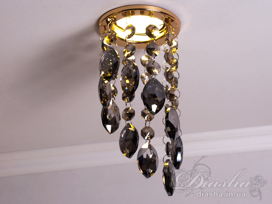 Цей розкішний врізний точковий світильник з кришталевими підвісами від ТМ &laquo;Діаша&raquo; віддзеркалює розкіш і вишуканість, пропонуючи більше ніж просте освітлення &ndash; він вносить елементи мистецтва та елегантності в інтер'єр. Ця унікальна освітлювальна прикраса втілює бездоганний баланс між функціональністю та дизайном, привносячи в будь-яку кімнату ауру ексклюзивності та стилю.
Кожен кришталь, відшліфований до досконалості, створює гіпнотичний ефект, м'яко відбиваючи світло та розкидаючи його по кімнаті у вигляді динамічного візерунка іскринок. Кришталі підвішені на тонких, ледве помітних нитках, ніби парять у повітрі, зачаровуючи своєю грацією та легкістю. Вони перетворюють кожен випадковий промінь світла в святковий феєрверк, наповнюючи простір теплим світінням та витонченою атмосферою.
Цей світильник ідеально підходить для вітальні, де він може стати яскравим акцентом та центром уваги, допомагаючи створити атмосферу розкоші та комфорту для прийому гостей. У кухні він додасть сяйва та благородства, підсилюючи апетитність страв та красу приготування. У спальні, врізний точковий світильник з кришталевими підвісами забезпечить м'яке та заспокійливе освітлення, створюючи ідеальне середовище для відпочинку та релаксації.
У громадських просторах, таких як кафе, світильник створить особливу, неповторну атмосферу, де кожен промінь світла виграє в кришталях, додаючи інтер'єру вишуканості та шарму. Придбати цей світильник можна недорого, що робить його доступним вибором для тих, хто бажає додати елементи розкоші в свій простір без зайвих витрат.
Стилістика світильника притаманна багатьом дизайнерським напрямкам: від класичного і ретро до сучасного мінімалізму та індустріального шику. Він уособлює в собі естетику, яка перевершує тренди, залишаючись актуальною та елегантною в будь-якій епосі.
