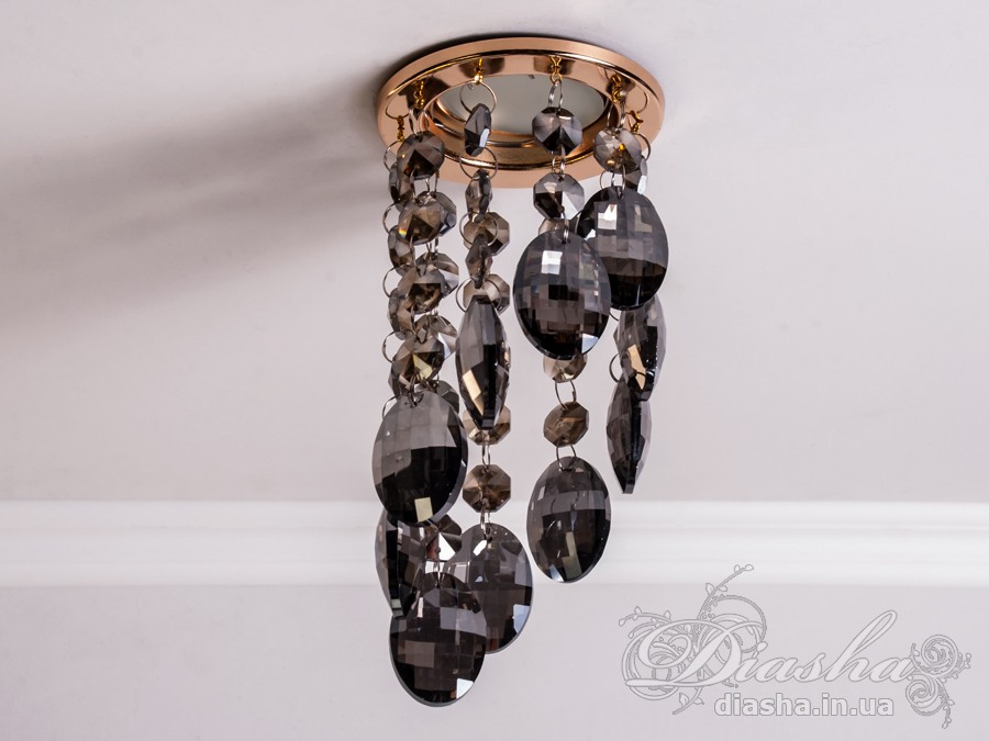 Цей врізний точковий світильник з кришталевими підвісами є витонченим та елегантним рішенням для тих, хто шукає унікальний освітлювальний прилад, здатний додати розкоші та благородства будь-якому інтер'єру. Він являє собою поєднання класики та сучасності, втілюючи розкішні традиції в оформленні оселі.
Світильник укомплектований багатогранними кришталевими підвісами, що відбивають світло, створюючи чарівний світловий спектакль із яскравими блискучими рефлексами на стінах і стелі. Кожен підвіс витончено розрізає промінь світла, перетворюючи його на безліч танцюючих іскор, які збагачують простір теплотою та мерехтливістю.
Такий світильник стане ідеальним вибором для залу, де його можна використовувати для створення акцентованого освітлення або для додання атмосфери вишуканості під час вечірніх зустрічей. У кухні точковий світильник з кришталевими підвісами може виступати як розкішний акцент, який не тільки висвітлює, але й прикрашає простір. У спальні він створить інтимну атмосферу, граючи з візерунками світла та тіні, надаючи кімнаті відчуття спокою та затишку.
У кафе або ресторанах такий світильник може стати особливим декоративним елементом, що привертає увагу відвідувачів та створює ефектний візуальний акцент. Його світло не тільки покращить видимість, але й додасть естетичної насолоди перебуванню в приміщенні.
Для тих, хто шукає купити дешево точковий світильник, ця модель від ТМ &laquo;Діаша&raquo; може стати відмінним рішенням, оскільки вона поєднує в собі привабливий зовнішній вигляд та доступність. Вона призначена для різноманітних стилів від класичного до сучасного, від арт-деко до мінімалізму, дозволяючи легко вписатися в будь-який декор.
Основна унікальність цього точкового світильника полягає в його здатності прикрасити та освітлити простір, роблячи його видатним та таким який легко запам&rsquo;ятовується. Він не просто виконує свою функцію освітлення, але й служить джерелом натхнення та краси, привносячи у повсякденне життя трохи чарівності та розкоші.