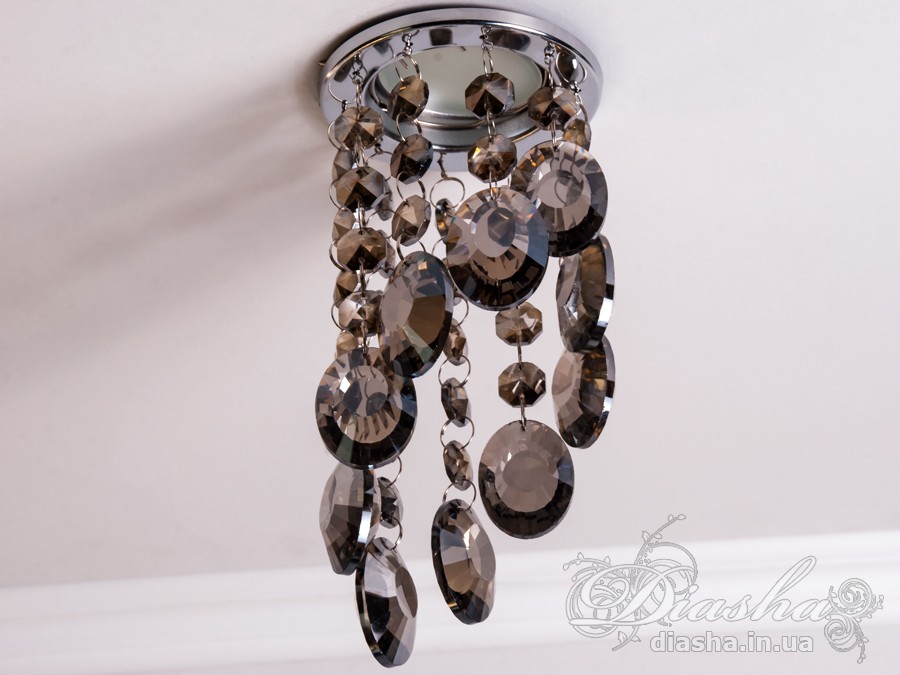 Цей розкішний врізний точковий світильник з кришталевими підвісами від ТМ &laquo;Діаша&raquo; віддзеркалює розкіш і вишуканість, пропонуючи більше ніж просте освітлення &ndash; він вносить елементи мистецтва та елегантності в інтер'єр. Ця унікальна освітлювальна прикраса втілює бездоганний баланс між функціональністю та дизайном, привносячи в будь-яку кімнату ауру ексклюзивності та стилю.
Кожен кришталь, відшліфований до досконалості, створює гіпнотичний ефект, м'яко відбиваючи світло та розкидаючи його по кімнаті у вигляді динамічного візерунка іскринок. Кришталі підвішені на тонких, ледве помітних нитках, ніби парять у повітрі, зачаровуючи своєю грацією та легкістю. Вони перетворюють кожен випадковий промінь світла в святковий феєрверк, наповнюючи простір теплим світінням та витонченою атмосферою.
Цей світильник ідеально підходить для вітальні, де він може стати яскравим акцентом та центром уваги, допомагаючи створити атмосферу розкоші та комфорту для прийому гостей. У кухні він додасть сяйва та благородства, підсилюючи апетитність страв та красу приготування. У спальні, врізний точковий світильник з кришталевими підвісами забезпечить м'яке та заспокійливе освітлення, створюючи ідеальне середовище для відпочинку та релаксації.
У громадських просторах, таких як кафе, світильник створить особливу, неповторну атмосферу, де кожен промінь світла виграє в кришталях, додаючи інтер'єру вишуканості та шарму. Придбати цей світильник можна недорого, що робить його доступним вибором для тих, хто бажає додати елементи розкоші в свій простір без зайвих витрат.
Стилістика світильника притаманна багатьом дизайнерським напрямкам: від класичного і ретро до сучасного мінімалізму та індустріального шику. Він уособлює в собі естетику, яка перевершує тренди, залишаючись актуальною та елегантною в будь-якій епосі.
