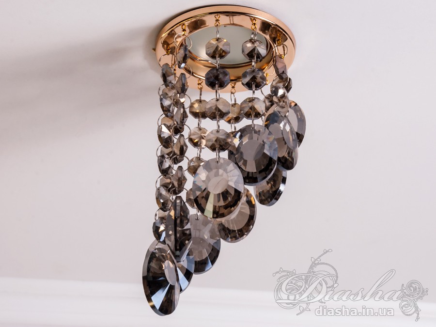 Врізний точковий світильник з кришталевими підвісами являє собою витончене освітлювальне рішення, яке здатне додати розкоші та величі будь-якому простору. Він демонструє багатство інтер'єрних можливостей, відбиваючи найтонші нюанси сучасного дизайну і при цьому підтримуючи класичну естетику.
Центральна частина світильника виконана з міцного металу, фініш якого імітує золото, додаючи елемент розкішного благородства. Від цієї центральної частини спускаються елегантні кришталеві підвіси, кожен з яких є маленьким витвором мистецтва. Криштали мають різноманітні грані, що ловлять світло і переломлюють його в блискучий калейдоскоп, створюючи чарівні ігри світла по всьому приміщенню.
Такий світильник стане чудовим доповненням до інтер'єру залу, де він може бути використаний для створення затишної атмосфери чи служити як основний акцент оформлення. У кухні він може допомогти виділити зону їдальні або підкреслити красу кухонних меблів. В спальні світильник забезпечить м'яке і романтичне освітлення, створюючи ідеальну атмосферу для відпочинку і релаксації.
У просторах кафе та інших громадських місць цей світильник зможе додати нотки ексклюзивності та статусу. Його кришталеві підвіси можуть служити не лише джерелом світла, а й елементом декору, що приваблює погляди і запам'ятовується відвідувачам.
Такий світильник легко можна придбати за доступною ціною, що робить його відмінним вибором для тих, хто прагне купити дешево точковий світильник, але не хоче жертвувати якістю та виглядом. Світильник від ТМ &laquo;Діаша&raquo; поєднує в собі стильність, елегантність та сучасну технологічність, будучи притаманним багатьом стилям від класики до модерну.
Врізний точковий світильник з кришталевими підвісами не просто освітлює простір - він перетворює його, додаючи кожному моменту особливу красу та чарівність, які лише кришталь здатний створити.