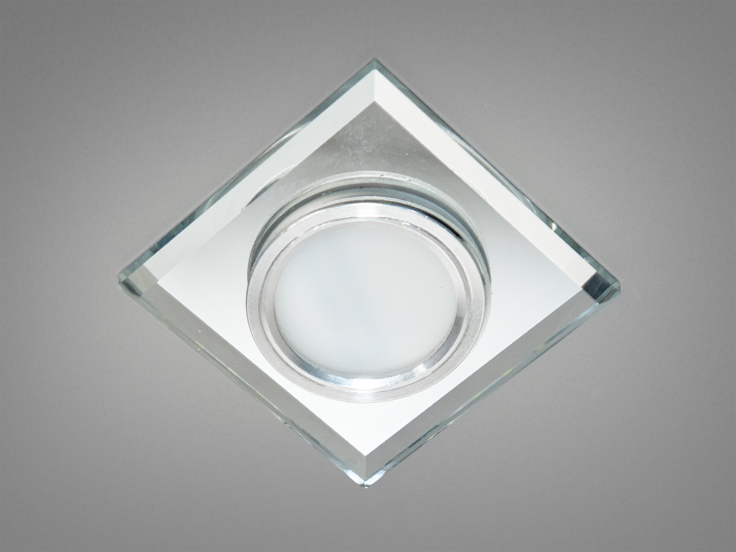 Точковий світильник з вбудованим LED підсвічуванням – це більше, ніж просто джерело світла: це вишукана деталь інтерєру, здатна підкреслити стиль та смак господарів будинку. Виконаний з прозорого скла з тонким огранюванням та доповнений металевою основою.