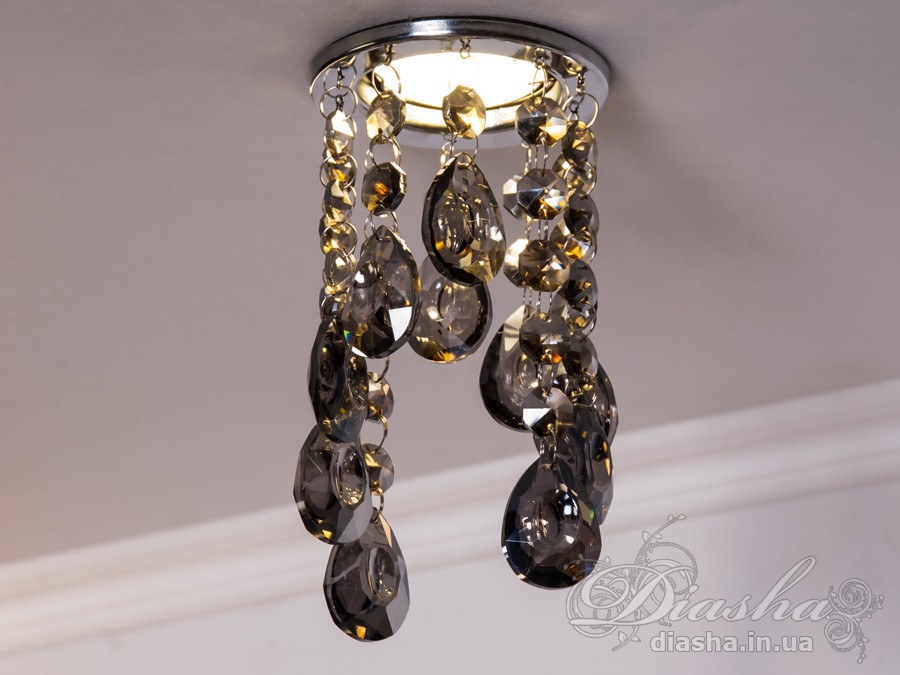 Цей врізний точковий світильник з кришталевими підвісами є витонченим та елегантним рішенням для тих, хто шукає унікальний освітлювальний прилад, здатний додати розкоші та благородства будь-якому інтер'єру. Він являє собою поєднання класики та сучасності, втілюючи розкішні традиції в оформленні оселі.
Світильник укомплектований багатогранними кришталевими підвісами, що відбивають світло, створюючи чарівний світловий спектакль із яскравими блискучими рефлексами на стінах і стелі. Кожен підвіс витончено розрізає промінь світла, перетворюючи його на безліч танцюючих іскор, які збагачують простір теплотою та мерехтливістю.
Такий світильник стане ідеальним вибором для залу, де його можна використовувати для створення акцентованого освітлення або для додання атмосфери вишуканості під час вечірніх зустрічей. У кухні точковий світильник з кришталевими підвісами може виступати як розкішний акцент, який не тільки висвітлює, але й прикрашає простір. У спальні він створить інтимну атмосферу, граючи з візерунками світла та тіні, надаючи кімнаті відчуття спокою та затишку.
У кафе або ресторанах такий світильник може стати особливим декоративним елементом, що привертає увагу відвідувачів та створює ефектний візуальний акцент. Його світло не тільки покращить видимість, але й додасть естетичної насолоди перебуванню в приміщенні.
Для тих, хто шукає купити дешево точковий світильник, ця модель від ТМ &laquo;Діаша&raquo; може стати відмінним рішенням, оскільки вона поєднує в собі привабливий зовнішній вигляд та доступність. Вона призначена для різноманітних стилів від класичного до сучасного, від арт-деко до мінімалізму, дозволяючи легко вписатися в будь-який декор.
Основна унікальність цього точкового світильника полягає в його здатності прикрасити та освітлити простір, роблячи його видатним та таким який легко запам&rsquo;ятовується. Він не просто виконує свою функцію освітлення, але й служить джерелом натхнення та краси, привносячи у повсякденне життя трохи чарівності та розкоші.