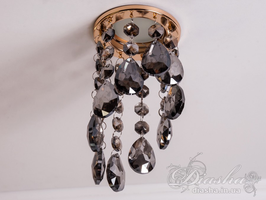 Бездоганна елегантність цього точкового світильника, поєднана з сяючим блиском високоякісного кришталю принесе Вам чимало приємних хвилин.
У центрі його уваги &ndash; кругле світлодіодне точкове джерело, яке ідеально освітлює приміщення. Його основа відзначається чистотою та сучасністю, але справжня витонченість починається по його обрамленню.
Крайові частини світильника прикрашають матовані чорні шестигранні кришталеві підвіси, розташовані по краях. Кожен із них &ndash; окрема скульптурна форма, створюючи чудовий ефект різноманіття та глибини. Кришталеві підвіси по краю світильника створюють геометричний ритм та гармонію.
Ці маленькі шестигранні підвіси слугують не лише декоративним елементом, але й функціональною частиною. Вони створюють градацію висоти, а до їхніх кінців підвішені великі кришталеві краплі, що нагадують про дорогоцінні каплі роси. Такий елементарний, але вишуканий дизайн додає світильнику витонченості та природності.
Різноманітні висоти кришталевих підвісів не лише створюють динаміку в образі, але і розвивають унікальний світловий пейзаж. Кришталі взаємодіють зі світлом, розсіюючи його і створюючи враження м'якої та атмосферної освітленості.
Цей точковий світильник ідеально вписується у сучасні інтер'єри, надаючи приміщенню не лише функціонального, але й художнього значення. Його здатність змінювати динаміку світла та створювати унікальну гру світла виявляється в кожному моменті, роблячи цей світильник як чудовим джерелом освітлення, так і витвором мистецтва, яке надихає та захоплює своєю естетикою.
Наш точковий світильник з кришталевими підвісками ідеально вписується в різноманітні стилі інтер'єру та може бути вдалим доповненням для різних приміщень:
Сучасний стиль (Modern): Своєю сучасною геометричною формою та інноваційним дизайном, світильник виглядає ефектно у сучасних приміщеннях, де важлива чистота ліній та мінімалістичний підхід до декору.
Сучасний класицизм (Modern Classic): Комбінація кришталевих деталей та чорного матового кольору додає елементи класичного стилю, що робить його вдалим вибором для класичних сучасних інтер'єрів.
Лофт (Loft): Чорне покриття та нестандартний дизайн роблять його відмінним вибором для стилізованих лофт-просторів, де важливі нестандартні елементи та сучасна естетика.
Еклектика (Eclectic): Завдяки унікальній формі та різноманіттю висот кришталевих підвісів, світильник може бути вдалою доповнюючою деталлю в інтер'єрах з еклектичним підходом, поєднуючи елементи різних стилів.
Розкіш (Luxury): Кришталеві деталі і високоякісне виконання роблять цей світильник відмінним вибором для розкішних інтер'єрів, де важливо створити враження розкоші та елегантності.
Щодо приміщень, цей світильник може бути впізнаним у:
Вітальнях та гостьових кімнатах: Як центральний акцент в приміщеннях для відпочинку.
Спальнях: Де його естетика може додати атмосфери розкоші та інтимності.
Ресторанах і вестибюлях готелів: Де важливо створити перше враження розкоші.
Офісах та конференц-залах: Де цей світильник може служити як елемент сучасного офісного дизайну.
Сучасних арт-просторах: Де його вишуканий дизайн може виглядати як самостійний об'єкт мистецтва.
Загалом, цей світильник демонструє універсальність та може бути успішно впроваджений в різних стилях та типах приміщень.
&nbsp;