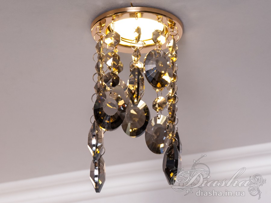 Бездоганна елегантність цього точкового світильника, поєднана з сяючим блиском високоякісного кришталю принесе Вам чимало приємних хвилин.
У центрі його уваги &ndash; кругле світлодіодне точкове джерело, яке ідеально освітлює приміщення. Його основа відзначається чистотою та сучасністю, але справжня витонченість починається по його обрамленню.
Крайові частини світильника прикрашають матовані чорні шестигранні кришталеві підвіси, розташовані по краях. Кожен із них &ndash; окрема скульптурна форма, створюючи чудовий ефект різноманіття та глибини. Кришталеві підвіси по краю світильника створюють геометричний ритм та гармонію.
Ці маленькі шестигранні підвіси слугують не лише декоративним елементом, але й функціональною частиною. Вони створюють градацію висоти, а до їхніх кінців підвішені великі кришталеві краплі, що нагадують про дорогоцінні каплі роси. Такий елементарний, але вишуканий дизайн додає світильнику витонченості та природності.
Різноманітні висоти кришталевих підвісів не лише створюють динаміку в образі, але і розвивають унікальний світловий пейзаж. Кришталі взаємодіють зі світлом, розсіюючи його і створюючи враження м'якої та атмосферної освітленості.
Цей точковий світильник ідеально вписується у сучасні інтер'єри, надаючи приміщенню не лише функціонального, але й художнього значення. Його здатність змінювати динаміку світла та створювати унікальну гру світла виявляється в кожному моменті, роблячи цей світильник як чудовим джерелом освітлення, так і витвором мистецтва, яке надихає та захоплює своєю естетикою.
Наш точковий світильник з кришталевими підвісками ідеально вписується в різноманітні стилі інтер'єру та може бути вдалим доповненням для різних приміщень:
Сучасний стиль (Modern): Своєю сучасною геометричною формою та інноваційним дизайном, світильник виглядає ефектно у сучасних приміщеннях, де важлива чистота ліній та мінімалістичний підхід до декору.
Сучасний класицизм (Modern Classic): Комбінація кришталевих деталей та чорного матового кольору додає елементи класичного стилю, що робить його вдалим вибором для класичних сучасних інтер'єрів.
Лофт (Loft): Чорне покриття та нестандартний дизайн роблять його відмінним вибором для стилізованих лофт-просторів, де важливі нестандартні елементи та сучасна естетика.
Еклектика (Eclectic): Завдяки унікальній формі та різноманіттю висот кришталевих підвісів, світильник може бути вдалою доповнюючою деталлю в інтер'єрах з еклектичним підходом, поєднуючи елементи різних стилів.
Розкіш (Luxury): Кришталеві деталі і високоякісне виконання роблять цей світильник відмінним вибором для розкішних інтер'єрів, де важливо створити враження розкоші та елегантності.
Щодо приміщень, цей світильник може бути впізнаним у:
Вітальнях та гостьових кімнатах: Як центральний акцент в приміщеннях для відпочинку.
Спальнях: Де його естетика може додати атмосфери розкоші та інтимності.
Ресторанах і вестибюлях готелів: Де важливо створити перше враження розкоші.
Офісах та конференц-залах: Де цей світильник може служити як елемент сучасного офісного дизайну.
Сучасних арт-просторах: Де його вишуканий дизайн може виглядати як самостійний об'єкт мистецтва.
Загалом, цей світильник демонструє універсальність та може бути успішно впроваджений в різних стилях та типах приміщень.