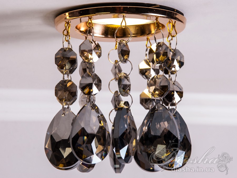 Врізний точковий світильник з кришталевими підвісами являє собою витончене освітлювальне рішення, яке здатне додати розкоші та величі будь-якому простору. Він демонструє багатство інтер'єрних можливостей, відбиваючи найтонші нюанси сучасного дизайну і при цьому підтримуючи класичну естетику.
Центральна частина світильника виконана з міцного металу, фініш якого імітує золото, додаючи елемент розкішного благородства. Від цієї центральної частини спускаються елегантні кришталеві підвіси, кожен з яких є маленьким витвором мистецтва. Криштали мають різноманітні грані, що ловлять світло і переломлюють його в блискучий калейдоскоп, створюючи чарівні ігри світла по всьому приміщенню.
Такий світильник стане чудовим доповненням до інтер'єру залу, де він може бути використаний для створення затишної атмосфери чи служити як основний акцент оформлення. У кухні він може допомогти виділити зону їдальні або підкреслити красу кухонних меблів. В спальні світильник забезпечить м'яке і романтичне освітлення, створюючи ідеальну атмосферу для відпочинку і релаксації.
У просторах кафе та інших громадських місць цей світильник зможе додати нотки ексклюзивності та статусу. Його кришталеві підвіси можуть служити не лише джерелом світла, а й елементом декору, що приваблює погляди і запам'ятовується відвідувачам.
Такий світильник легко можна придбати за доступною ціною, що робить його відмінним вибором для тих, хто прагне купити дешево точковий світильник, але не хоче жертвувати якістю та виглядом. Світильник від ТМ &laquo;Діаша&raquo; поєднує в собі стильність, елегантність та сучасну технологічність, будучи притаманним багатьом стилям від класики до модерну.
Врізний точковий світильник з кришталевими підвісами не просто освітлює простір - він перетворює його, додаючи кожному моменту особливу красу та чарівність, які лише кришталь здатний створити.