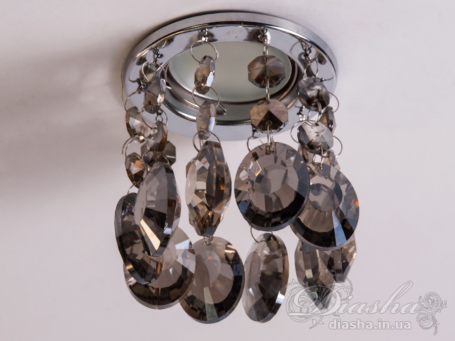 Бездоганна елегантність цього точкового світильника, поєднана з сяючим блиском високоякісного кришталю принесе Вам чимало приємних хвилин.
У центрі його уваги &ndash; кругле світлодіодне точкове джерело, яке ідеально освітлює приміщення. Його основа відзначається чистотою та сучасністю, але справжня витонченість починається по його обрамленню.
Крайові частини світильника прикрашають матовані чорні шестигранні кришталеві підвіси, розташовані по краях. Кожен із них &ndash; окрема скульптурна форма, створюючи чудовий ефект різноманіття та глибини. Кришталеві підвіси по краю світильника створюють геометричний ритм та гармонію.
Ці маленькі шестигранні підвіси слугують не лише декоративним елементом, але й функціональною частиною. Вони створюють градацію висоти, а до їхніх кінців підвішені великі кришталеві краплі, що нагадують про дорогоцінні каплі роси. Такий елементарний, але вишуканий дизайн додає світильнику витонченості та природності.
Різноманітні висоти кришталевих підвісів не лише створюють динаміку в образі, але і розвивають унікальний світловий пейзаж. Кришталі взаємодіють зі світлом, розсіюючи його і створюючи враження м'якої та атмосферної освітленості.
Цей точковий світильник ідеально вписується у сучасні інтер'єри, надаючи приміщенню не лише функціонального, але й художнього значення. Його здатність змінювати динаміку світла та створювати унікальну гру світла виявляється в кожному моменті, роблячи цей світильник як чудовим джерелом освітлення, так і витвором мистецтва, яке надихає та захоплює своєю естетикою.
Наш точковий світильник з кришталевими підвісками ідеально вписується в різноманітні стилі інтер'єру та може бути вдалим доповненням для різних приміщень:
Сучасний стиль (Modern): Своєю сучасною геометричною формою та інноваційним дизайном, світильник виглядає ефектно у сучасних приміщеннях, де важлива чистота ліній та мінімалістичний підхід до декору.
Сучасний класицизм (Modern Classic): Комбінація кришталевих деталей та чорного матового кольору додає елементи класичного стилю, що робить його вдалим вибором для класичних сучасних інтер'єрів.
Лофт (Loft): Чорне покриття та нестандартний дизайн роблять його відмінним вибором для стилізованих лофт-просторів, де важливі нестандартні елементи та сучасна естетика.
Еклектика (Eclectic): Завдяки унікальній формі та різноманіттю висот кришталевих підвісів, світильник може бути вдалою доповнюючою деталлю в інтер'єрах з еклектичним підходом, поєднуючи елементи різних стилів.
Розкіш (Luxury): Кришталеві деталі і високоякісне виконання роблять цей світильник відмінним вибором для розкішних інтер'єрів, де важливо створити враження розкоші та елегантності.
Щодо приміщень, цей світильник може бути впізнаним у:
Вітальнях та гостьових кімнатах: Як центральний акцент в приміщеннях для відпочинку.
Спальнях: Де його естетика може додати атмосфери розкоші та інтимності.
Ресторанах і вестибюлях готелів: Де важливо створити перше враження розкоші.
Офісах та конференц-залах: Де цей світильник може служити як елемент сучасного офісного дизайну.
Сучасних арт-просторах: Де його вишуканий дизайн може виглядати як самостійний об'єкт мистецтва.
Загалом, цей світильник демонструє універсальність та може бути успішно впроваджений в різних стилях та типах приміщень.
&nbsp;