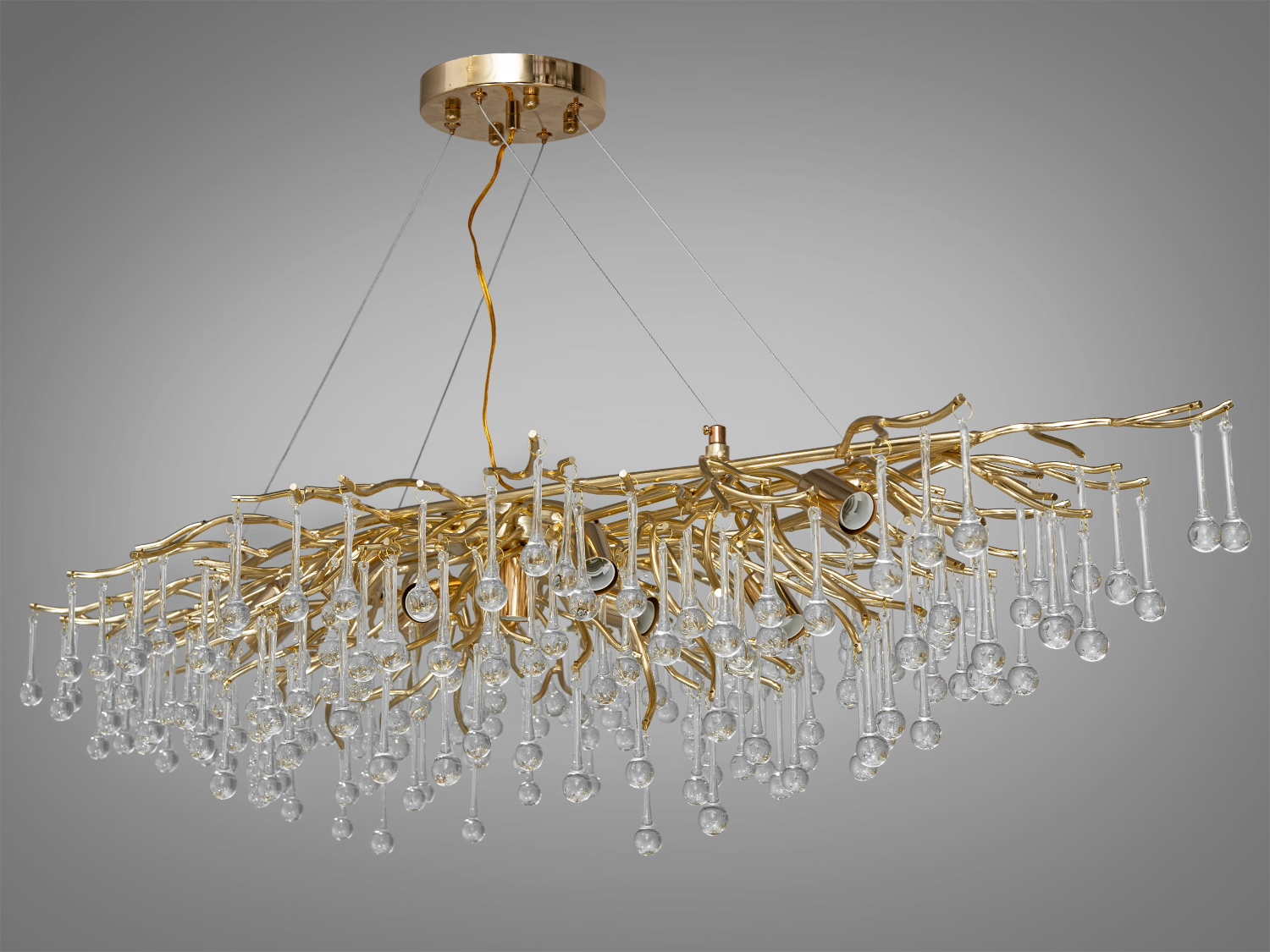 Оригінальна кришталева люстра витягнутої форми в їдальню також застосовується для вітальні, зали, спальні, коридору або холу, гармонійно вписуючись в будь-який сучасний інтер'єр.
Особливість витягнутої форми цієї кришталевої люстри робить її не тільки унікальною, але й багатофункціональним вибором. Така її конструкція дозволяє створити безперервний візуальний потік світла, що робить її ідеальним вибором для просторів, де потрібно підкреслити лінійність простору, наприклад, над довгим обіднім столом або в просторій вітальні.
Конструкція люстри починається з простої, але елегантної алюмінієвої основи, що кріпиться до стелі. Звідси розгалужуються тонкі, майже невагомі алюмінієві гілки, розкидані хаотично, як гілки дерева в зимовому саду. Кожна гілка прикрашена кришталевими підвісками у формі краплі, що нагадують сльози принца Руперта, відомі як 