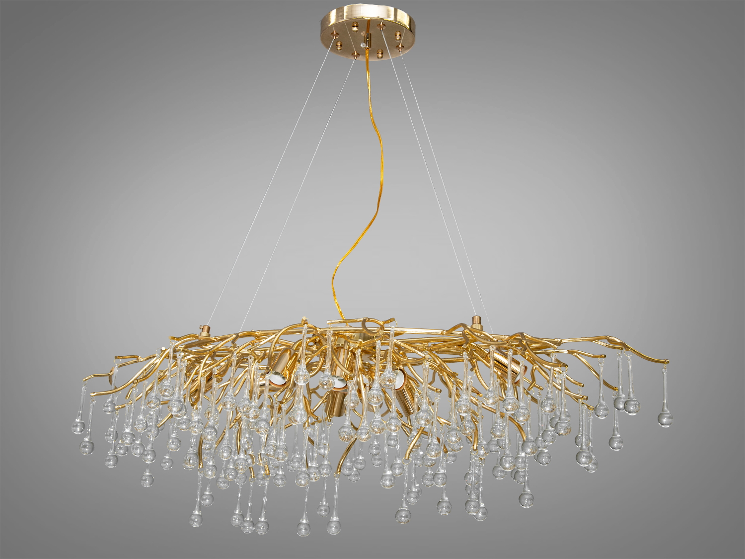 Багата кришталева люстра витягнутої форми в спальню також застосовується для вітальні, зали, спальні, коридору або холу, гармонійно вписуючись в будь-який сучасний інтер'єр.
Особливість витягнутої форми цієї кришталевої люстри робить її не тільки унікальною, але й багатофункціональним вибором. Така її конструкція дозволяє створити безперервний візуальний потік світла, що робить її ідеальним вибором для просторів, де потрібно підкреслити лінійність простору, наприклад, над довгим обіднім столом або в просторій вітальні.
Конструкція люстри починається з простої, але елегантної алюмінієвої основи, що кріпиться до стелі. Звідси розгалужуються тонкі, майже невагомі алюмінієві гілки, розкидані хаотично, як гілки дерева в зимовому саду. Кожна гілка прикрашена кришталевими підвісками у формі краплі, що нагадують сльози принца Руперта, відомі як 
