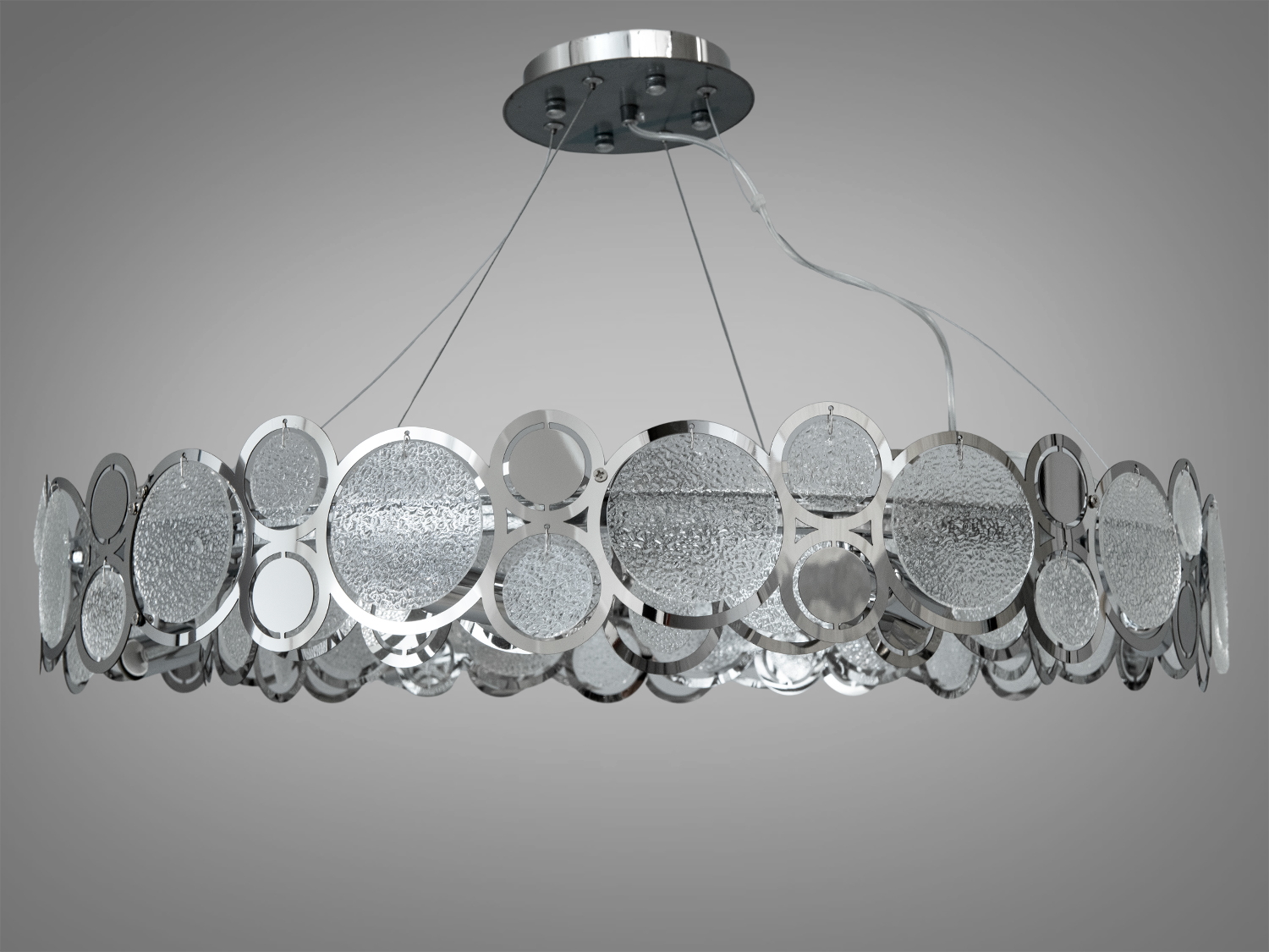 Дизайнерська люстра для залу з круглими елементами виготовлена зі скляних пелюсток замість металевих. На неї можна дивитися під будь-яким кутом, і не дивлячись на легкість конструкції люстри, ви завжди бачитимете лампи тільки через тоноване скло. 