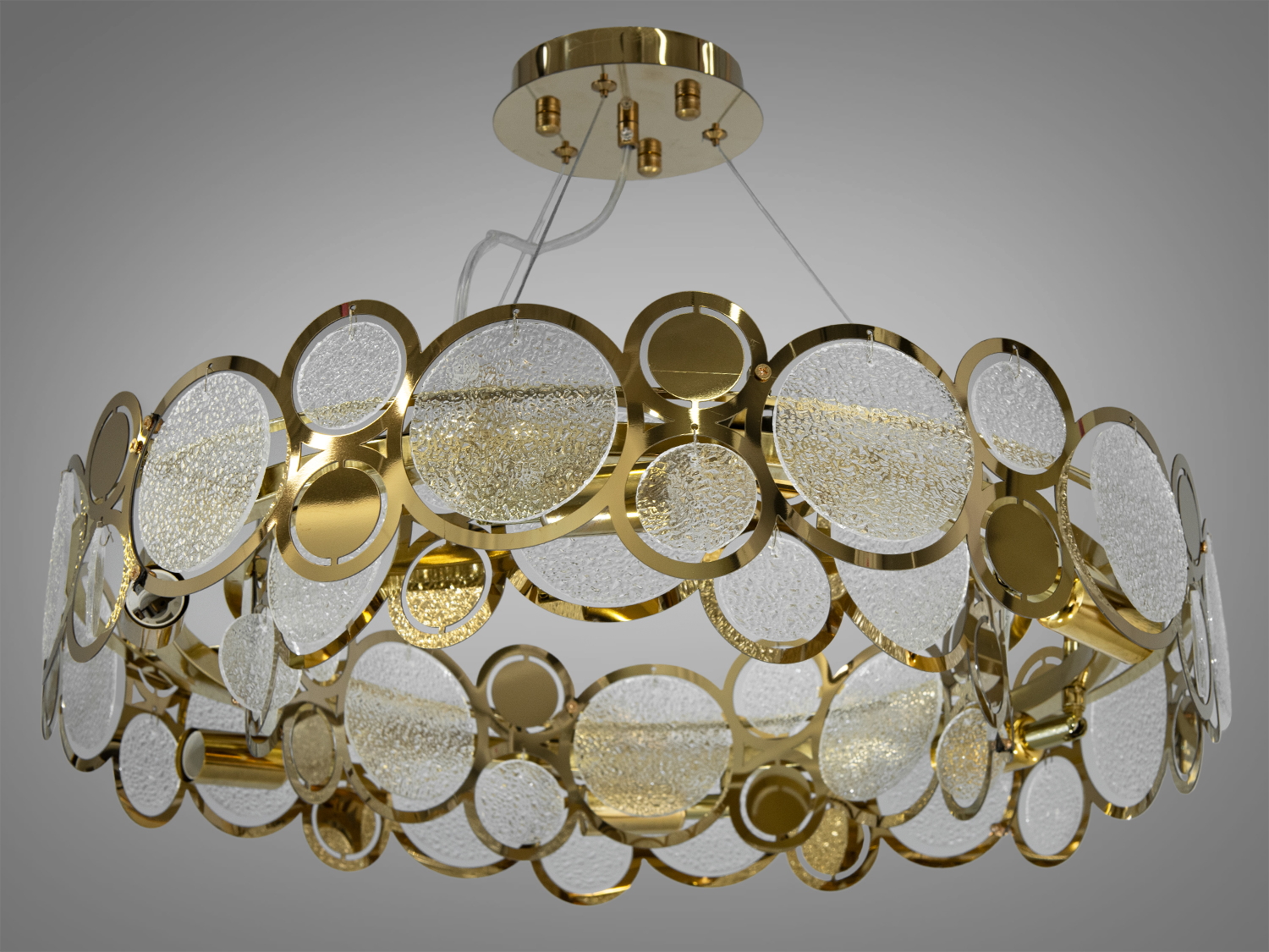 Люстра підвіс із круглими скляними елементами ідеально підходить для інтер'єрів, де переважає сучасний дизайн з елементами арт-деко або модерну. Доречна люстра у вітальню, де вона може стати центральним елементом інтер'єру, або в елегантних ресторанах, де прагнуть створити атмосферу розкоші та вишуканості.
Люстра класика на тросах підвісах, яка одразу кидає виклик звичайності та уособлює ексклюзивність у кожному своєму елементі. Ця підвісна світлова інсталяція має золотий каркас, що надає їй виразності та шику. Округлі скляні елементи, що переплітаються з металевою основою, створюють захоплюючий ефект калейдоскопа, який розсіює світло, даючи приміщенню відчуття глибини та багатогранності.
Завдяки регульованому підвісу є можливість варіювати висоту люстри, ідеально вписуючи її в простір вітальні або їдальні. Сучасна люстра під класичну лампу розжарювання, економку або світлодіодну лампу з цоколем Е14.
Стельове кріплення на планку універсальне та підходить для навісних, натяжних та звичайних стель.
Увага. Вага люстри 6.5 кг.
Лампи до комплекту не входять.