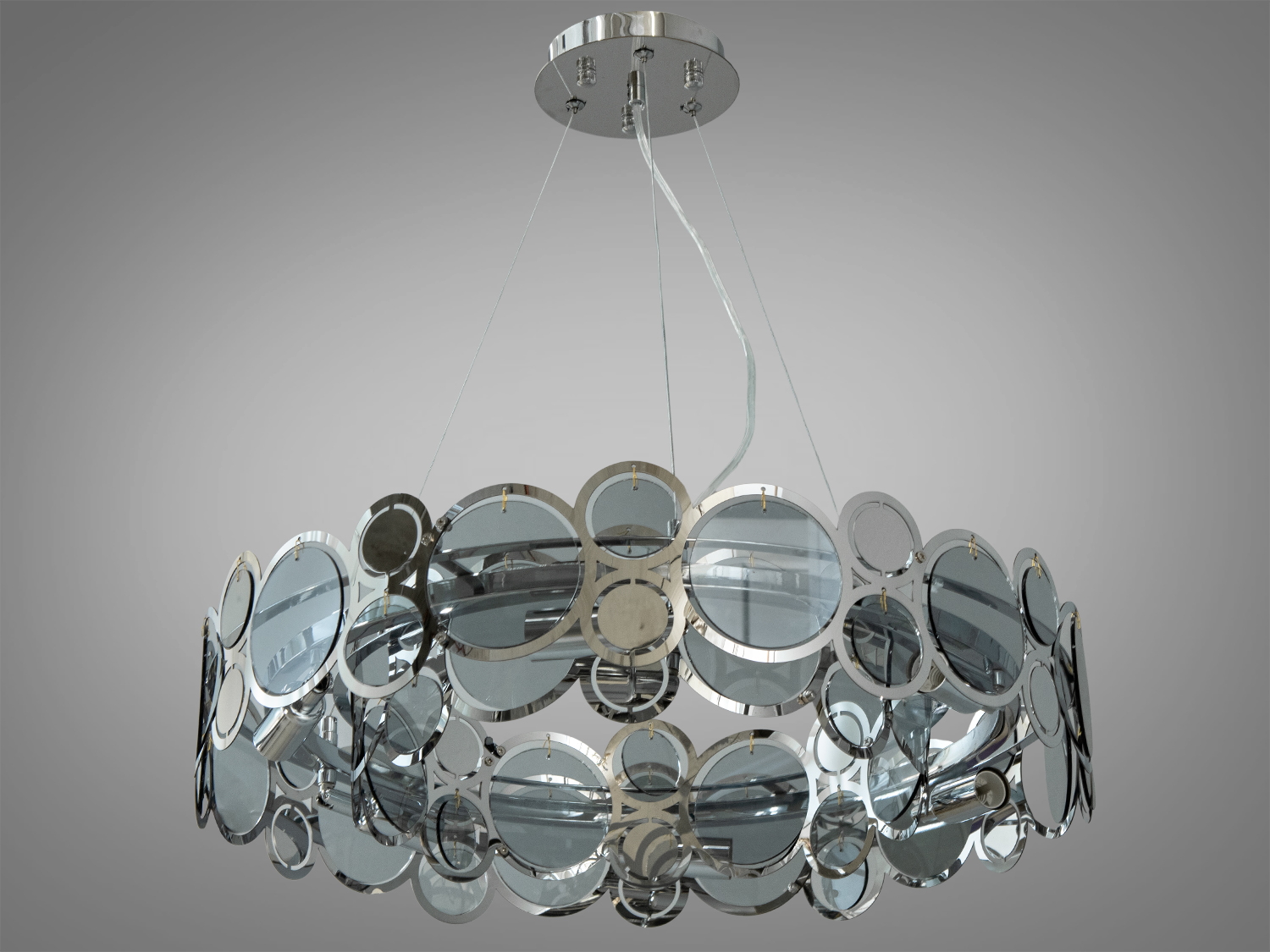 Кругла підвісна люстра у вітальню виконана зі скляних пелюсток замість металевих. На неї можна дивитися під будь-яким кутом, і не дивлячись на легкість конструкції люстри, ви завжди бачитимете лампи тільки через тоноване скло.