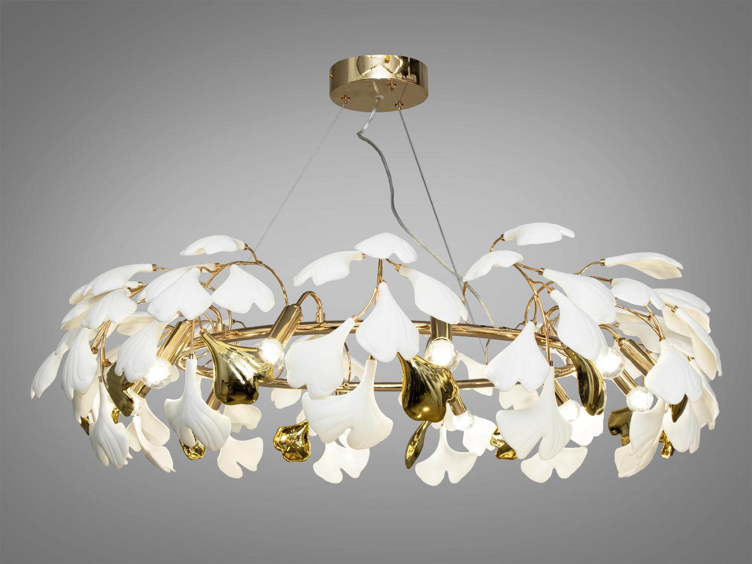 Вишукана люстра для залу з порцеляновими елементами також добре виглядатиме в інтер'єрі спальні, зали, вітальні, їдальні, квартирі студії, як у стилі лофт, так і в класичному інтер'єрі. Також ідеально впишеться в сучасні будинки, квартири, кафе, арт-простір, коворкінги, квеструми.
Ця вишукана люстра є шедевром дизайну, який набуває гармонії між природною красою і сучасною естетикою з ніжними керамічними пелюстками, що мають форму листя гінкго білоба - дерева. Їхній природний мотив уособлює спокій та розслаблення, приносячи в інтер'єр елементи природної гармонії, створюючи в інтер'єрі неповторну атмосферу.
Регульована висота люстри дозволяє змінювати розташування світильника залежно від потреб простору, забезпечуючи оптимальне освітлення та створення затишку у вашому будинку. Така люстра з пелюстками у формі листя гінкго стане центральним елементом оформлення приміщення, додавши до нього стиль, елегантність та трохи природної магії.
Люстра-підвіс під звичайні лампочки розжарювання, економки або світлодіодні лампи із цоколем Е14. Кріпиться до навісних, натяжних і звичайних стель універсальним кріпленням-на планку.
Лампа до комплекту не входить.