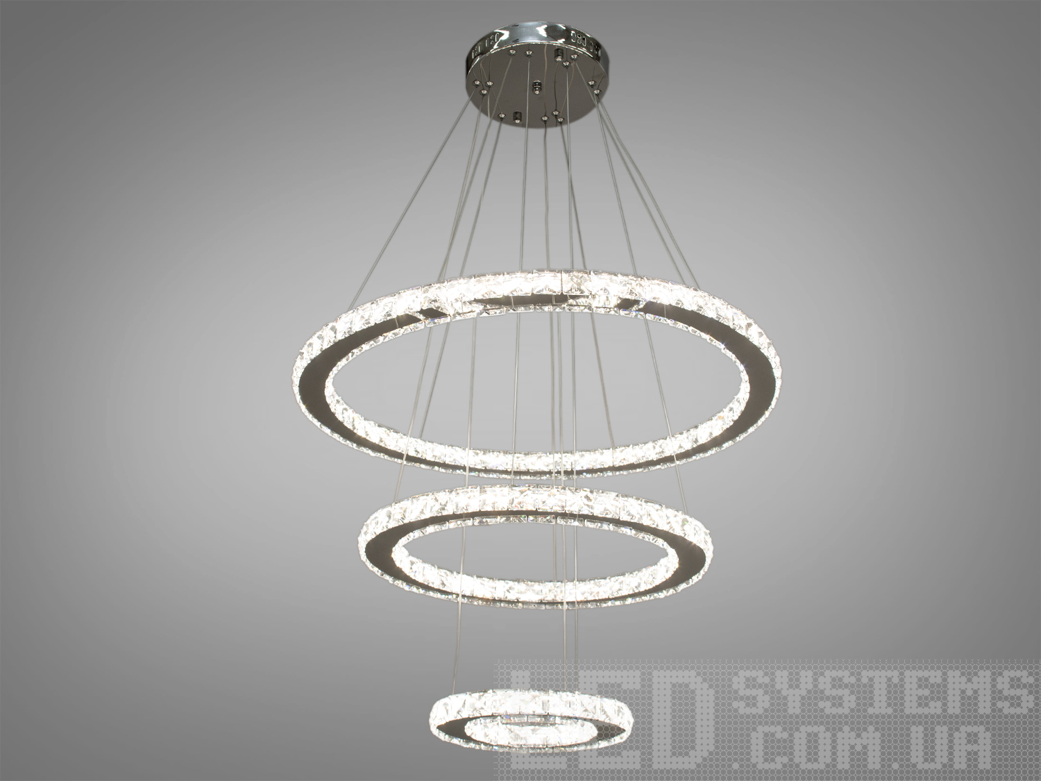 Стильна кришталева світлодіодна люстра-підвіс для холу також ідеально підходить для використання в холах або вітальнях, сходових зонах приватних будинків, ресторанах чи готелях, люксових спальнях, балконах або у вестибюлі, бізнес-центри або офісні простори.
Загальна концепція люстри робить її універсальною та здатною доповнювати різні стилі інтер'єру, такі як: класичний стиль, сучасний мінімалізм, еклектика, ретро чи вінтаж, люксовий модерн, бароко чи рококо.
Загальна потужність люстри - 80 Вт, що забезпечує достатнє освітлення для приміщення різних розмірів. Висота люстри &ndash; 100 см, що дозволяє їй стати центральним акцентом кімнати, створюючи враження величі та розкоші.
Функціональною особливістю цієї люстри є наявність пульта дистанційного керування. Завдяки регулюванню колірної температури 3200,4100,6000К, ви зможете вибрати той режим освітлення, який найбільше відповідає вашим потребам: тепле світло для розслаблення, нейтральне для роботи або холодне для концентрації. Режим увімкнення забезпечує швидкий доступ до різних режимів освітлення.
Починаючи з верхнього кришталевого кільця, що граційно спускається вниз, кожне наступне кільце вражає своєю елегантністю та пропорційністю. Рівновіддалені кільця, що послідовно зменшуються, створюють враження легкості та гармонії.
Основа кришталевого кільця виготовлена з високоякісного металу, який не тільки забезпечує стійкість та надійність, але й служить чудовою основою для блиску кристалів.
Кріпляться до стель будь-якого типу універсальним кріпленням на монтажну планку.