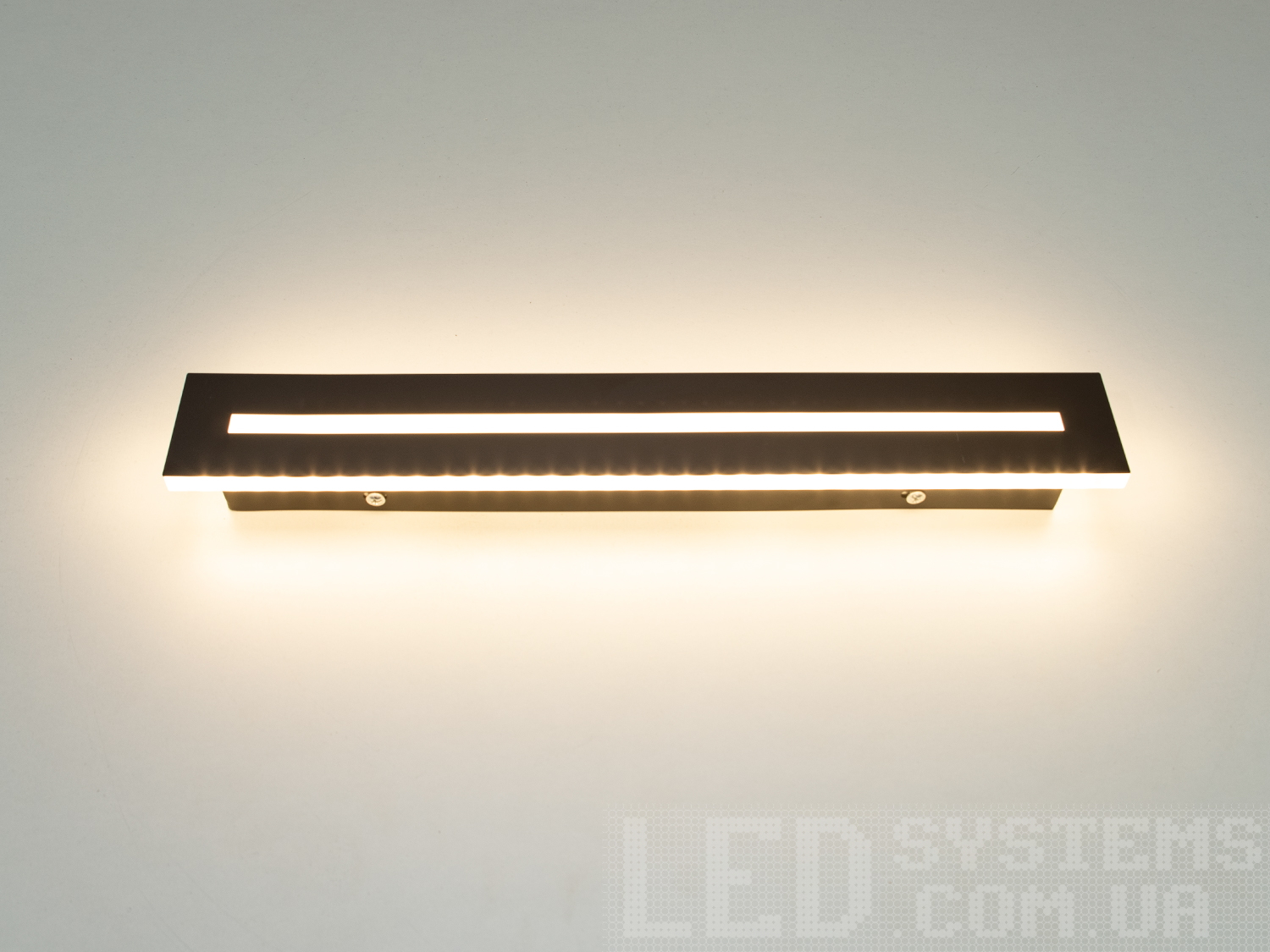 Мінімалістичний LED світильник-планка з незвичайним виконанням плафонів, що обрамляють LED лампи. LED світильник є ідеальним рішенням для акцентного (елементного) підсвічування в інтер'єрі - підсвічування дзеркал, картин, стінних ніш, особливих деталей інтер'єру і є не просто утилітарним світильником як звичайне лінійне підсвічування. Світильник має унікальні світлодіодні енергозберігаючі лампи. Які за дуже низької споживаної потужності створюють потужний світловий потік. Витончені накладні світлодіодні світильники призначені для створення яскравого світлодіодного освітлення з регульованою температурою кольору від теплого білого до холодного білого. Перемикання спектрів світіння світлодіодного світильника здійснюється простим вимкненням-вмиканням. Кріпиться до будь-яких видів поверхонь універсальним кріпленням-на планку.
