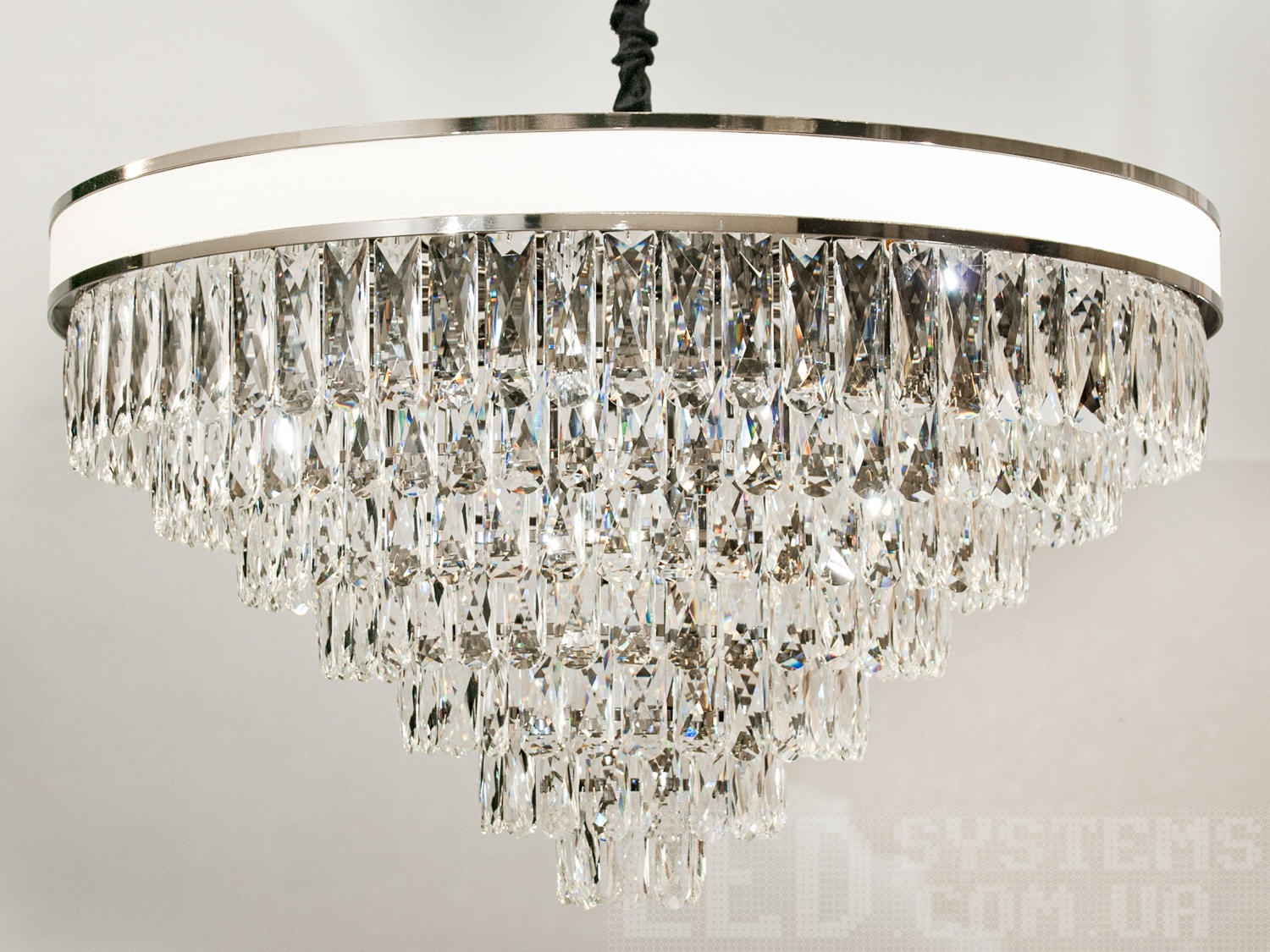 Сучасна кришталева люстра для залу, колір хром в сучасному виконанні з металевим корпусом і кришталевими підвісами добре буде виглядати в інтер'єрі залу, вітальні, їдальні.&nbsp;Висота люстри регулюється, завдяки чому підходить невисоких стель. У класичний інтер'єр вона вносить нотки сучасності, і легкої грайливості, а квартирі студії в стилі лофт дарує крапельку строгості і впорядкованості.&nbsp;Стельове кріплення на планку універсальне і підходить для навісних, натяжних і звичайних стель. Люстра-подвес під звичайні лампочки розжарювання, економки, або світлодіодні лампи з цоколем Е14.&nbsp;
Увага. Вага люстри 22,5кг .