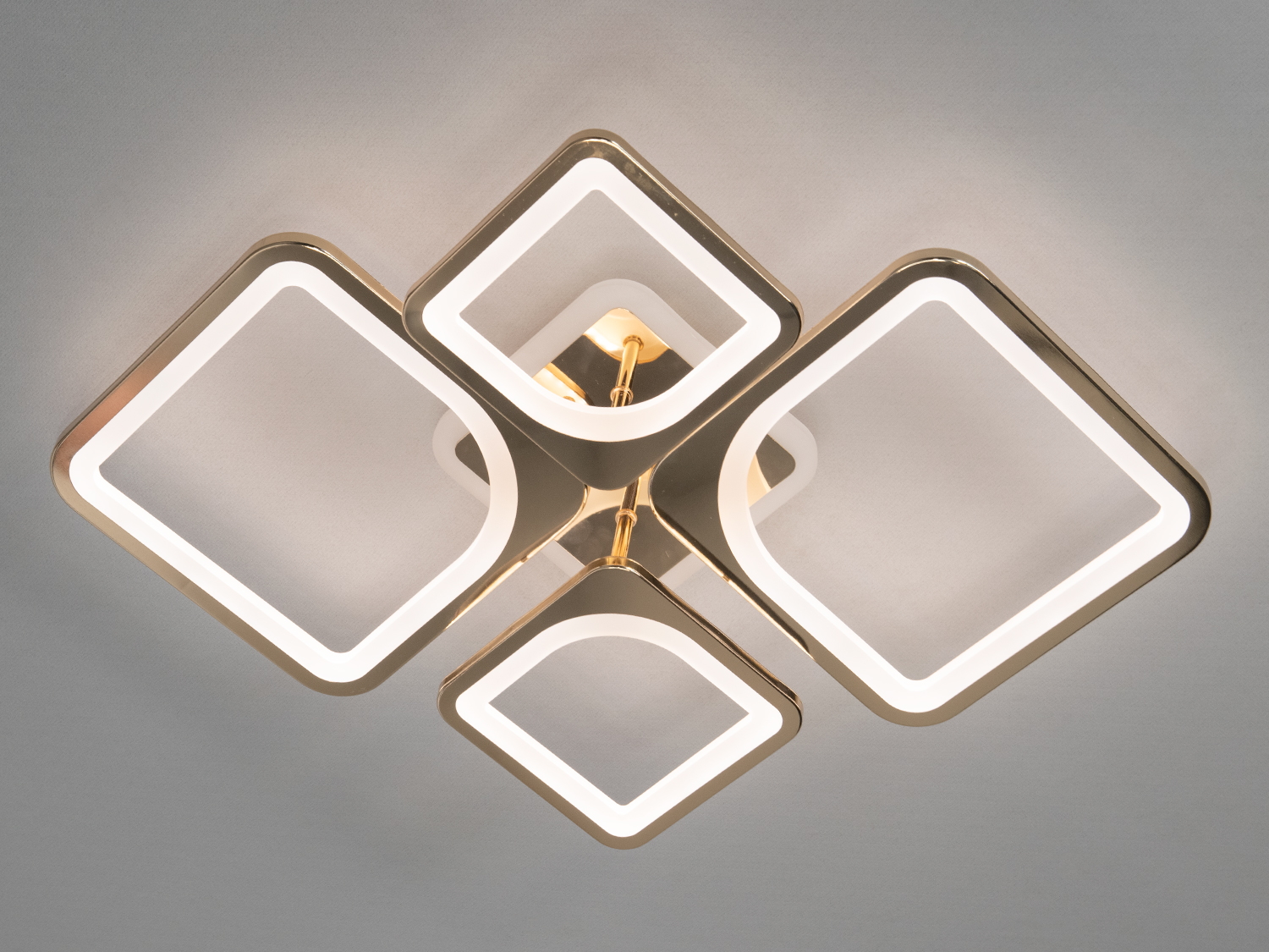 LED люстра на кухню з димером - втілення сучасного мистецтва у освітленні. Її унікальна конструкція з чотирьох квадратів, що перетинаються, створює ефект динамічного руху, а плавні лінії із золотистою обробкою надають вишуканості і витонченості.