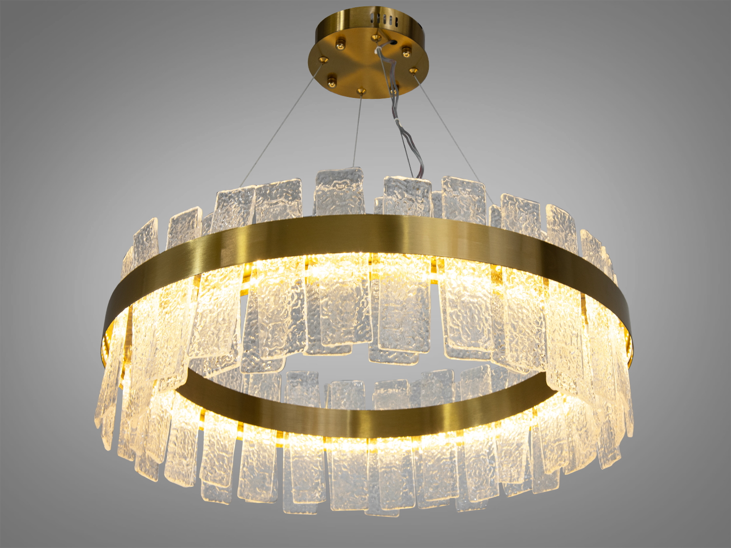 Вишукана кришталева LED люстра для залу також ідеально підійде для невеликих приміщень, і навіть для низьких стель, тому що висота регулюється, наприклад, у коридор, кухню, спальню, для залу або у вітальню.
Світлодіодна люстра має кілька режимів: холодний 6000К, нейтральний 4100К, теплий 3200К. Перемикання здійснюється з настінного вимикача почерговим включенням/вимкненням. Світлодіоди дозволяють підбирати необхідну температуру світла. Використання гнучкого світлодіодного модуля в люстрі дозволяє вивести естетичні якості на новий сучасний рівень.
Конструкція люстри складається з міцної металевої основи, що має гарний матовий відтінок золота, що надає виробу шарму та розкоші. Вона містить безліч прямокутних кришталевих підвісок, які мають неправильну текстуру, нагадуючи замерзлу воду чи природні мінерали. Кришталики розташовані в два ряди і створюють відчуття пишності та глибини. Світло, проходячи крізь ці підвіски, надає інтер'єру вишуканості. Розглядаючи цю люстру, слід відзначити переваги світлодіодного освітлення: воно енергоефективне, має великий термін служби та забезпечує відмінну якість світла.
Кріпиться до стелі (гіпсокартонним, навісним, натяжним) універсальним кріпленням-на планку.