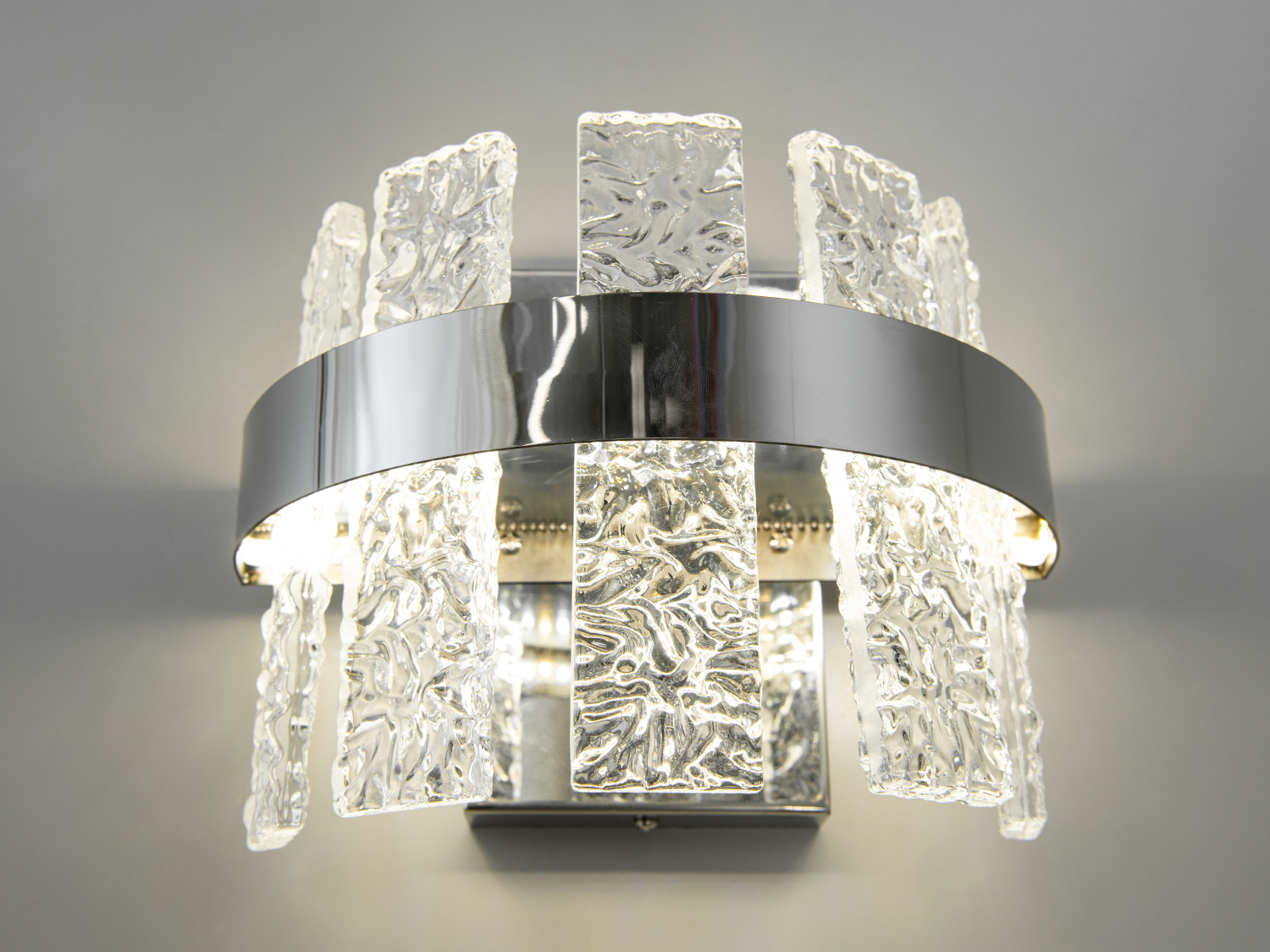 Сучасний настінний LED світильник в спальню з потужністю 18Вт видає достатньо світла, щоб бути самодостатнім джерелом підсвічування, дозволяє м'яко підсвітити простір, створюючи почуття тепла і затишку, необхідне для вечірнього релаксу.
За допомогою вимикача можна змінювати колірну температуру світильника: теплий 3200&deg;К, нейтральний 4100&deg;К, холодний 6000&deg;К. Колірна температура перемикається простим вимкненням-вмиканням світильника.
Функціональність світильника доповнюється його стильним зовнішнім виглядом, де кожна деталь продумана до дрібниць, золотий колір каркасу поєднується з прозорістю підвісів, створюючи відчуття розкішної легкості та елегантності.
Кріпиться до настінних поверхонь будь-якого типу універсальним кріпленням на монтажну планку.