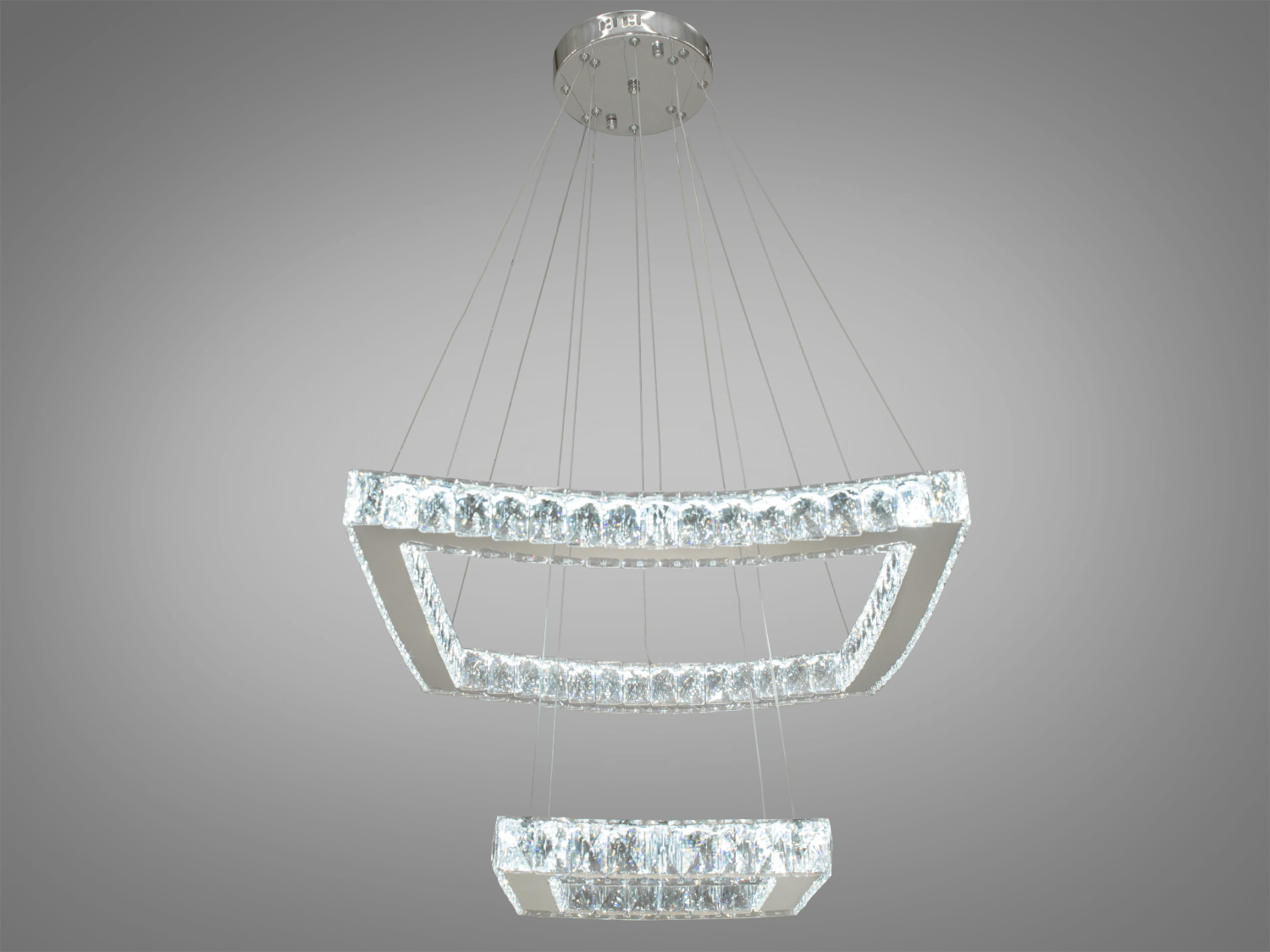 Каскадна кришталева світлодіодна люстра у вітальню також ідеально підходить для використання в холах або вітальні, сходових зонах приватних будинків, ресторанів або готелях, люксових спальнях, балконах або у вестибюлі, бізнес-центри або офісні простори.
Загальна концепція люстри робить її універсальною та здатною доповнювати різноманітні стилі інтер'єру, таких як: класичний стиль, сучасний мінімалізм, еклектика, ретро чи вінтаж, люксовий модерн, бароко чи рококо.
Ця люстра з її хромованою металевою основою і квадратними кільцями, що знаходяться паралельно один одному в просторі, висвітлює приміщення і надають вишуканості інтер'єру.
Потужність світильника 65 Вт та легкість його конструкції створюють ідеальне поєднання функціональності та вишуканості. Світлодіоди, вкраплені в кришталі по периметру кожного кільця, проектують світло, що динамічно відбивається і розсіює, створюючи в просторі гру світла і тіні. Ширина та довжина люстри становлять 55 см, а регульована висота 100 см дозволяє ідеально вписати її у простори різної величини та конфігурації.
Унікальність цієї люстри полягає у можливості регулювання колірної температури світла з вимикача або пульта, пропонуючи вибір між теплим світлом 3200K, нейтральним 4100K та холодним 6000K, що дозволяє адаптувати освітлення до настрою та потреб. У комплект входить пульт дистанційного керування, що надає додаткового комфорту у використанні.
Кріпиться до стелі будь-якого типу універсальним кріпленням на монтажну планку.