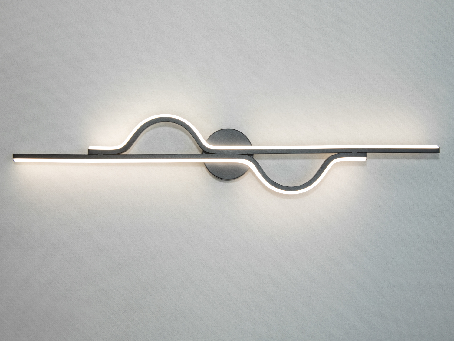 Оригінальний світлодіодний світильник на стіну – справжній танець світла та форми. Його хвилеподібний силует ніби повторює природні ритми: мякі вигини нагадують лінії горизонту, рух води або грацію звукової хвилі