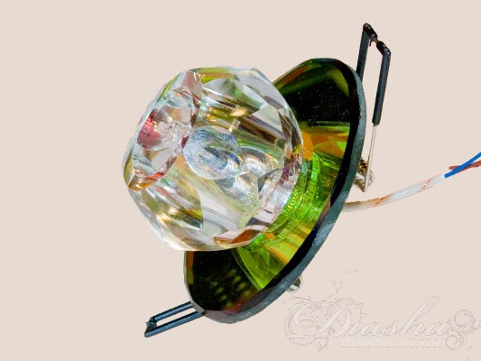 Точковий світильник мультиколор є справжнім втіленням святковості та кольорового різноманіття в дизайні освітлювальних приладів. Він складається з багатофасетованих елементів оптичної смоли, які разом створюють приголомшливий візуальний ефект, подібно до величного кристалу, що розсіює світло на множину блискучих відблисків.
Середина світильника оснащена лампою, що випромінює світло через прозору центральну секцію, надаючи глибини та яскравості кольоровим фасетам. Колірні відтінки світильника варіюються від теплих золотистих до багатих фіолетових тонів, створюючи різнобарвне світлове шоу в приміщенні.
Такий світильник стане виразним акцентом в будь-якому інтер'єрі, особливо підходячи до просторів, де бажано додати елемент розкоші або театральної драматичності. Він ідеально вписується в сучасні, арт-деко, а також бохо-стилі, де кожен відтінок може бути підкреслений через декор чи меблі.
Цей світильник не тільки служитиме основним джерелом світла, а й стане предметом мистецтва, що додасть характеру та індивідуальності кожній кімнаті. Він особливо підійде для створення унікальної атмосфери в місцях для відпочинку або в зонах рецепції, де важливе перше враження.
Точковий врізний світильник є універсальним освітлювальним рішенням, яке може використовуватися в широкому спектрі дизайнів інтер'єрів та приміщень завдяки своїй адаптивності та стильному зовнішньому вигляду. Ось декілька ідей, як і де його можна застосовувати:

Домашній інтер'єр:


У вітальнях для створення акцентованого освітлення або забезпечення додаткового світла у темних куточках.
У спальнях над ліжком або столиком для читання та інших активностей.
На кухнях над робочими зонами, для освітлення областей приготування їжі.
У ванних кімнатах для додавання чистого та свіжого світла, особливо біля дзеркал.
У передпокоях та коридорах для вітання гостей затишним освітленням.


Комерційні простори:


В офісах та конференц-залах для створення робочої атмосфери із здатністю акцентувати на презентаційних зонах.
У ресторанах та кафе для створення інтимної атмосфери з можливістю освітлення окремих столів або декоративних елементів.
В готельних лобі та коридорах для розкішного вигляду та функціонального освітлення.
У магазинах і торгових залах для привернення уваги до товарів та створення привабливого комерційного простору.


Освітлення архітектурних елементів:


Для підсвічування скульптур, картин або інших арт-об'єктів.
Акцентування архітектурних деталей, як-от колон, ніш або декоративних стель.


Зовнішнє використання:


Хоча це і внутрішні світильники, вони можуть використовуватися на закритих верандах або терасах, де немає прямого впливу погодних умов.

Завдяки використанню світлодіодних технологій, ці світильники забезпечують ефективне та тривале освітлення, знижуючи енергоспоживання та витрати на обслуговування, що робить їх ідеальними для тривалого щоденного використання в різних умовах. Вони також пропонують велику гнучкість у дизайні освітлення, дозволяючи легко міняти загальну атмосферу приміщення або привертати увагу до конкретних декоративних елементів чи областей.
Крім того, точкові світильники можуть використовуватись у приміщеннях, де важливе регулювання рівня освітлення, наприклад, в кінозалах, театрах, фото або художніх студіях, де необхідно створити особливу атмосферу для презентації творів мистецтва чи під час перегляду фільмів.
Таким чином, точковий врізний світильник від ТМ 