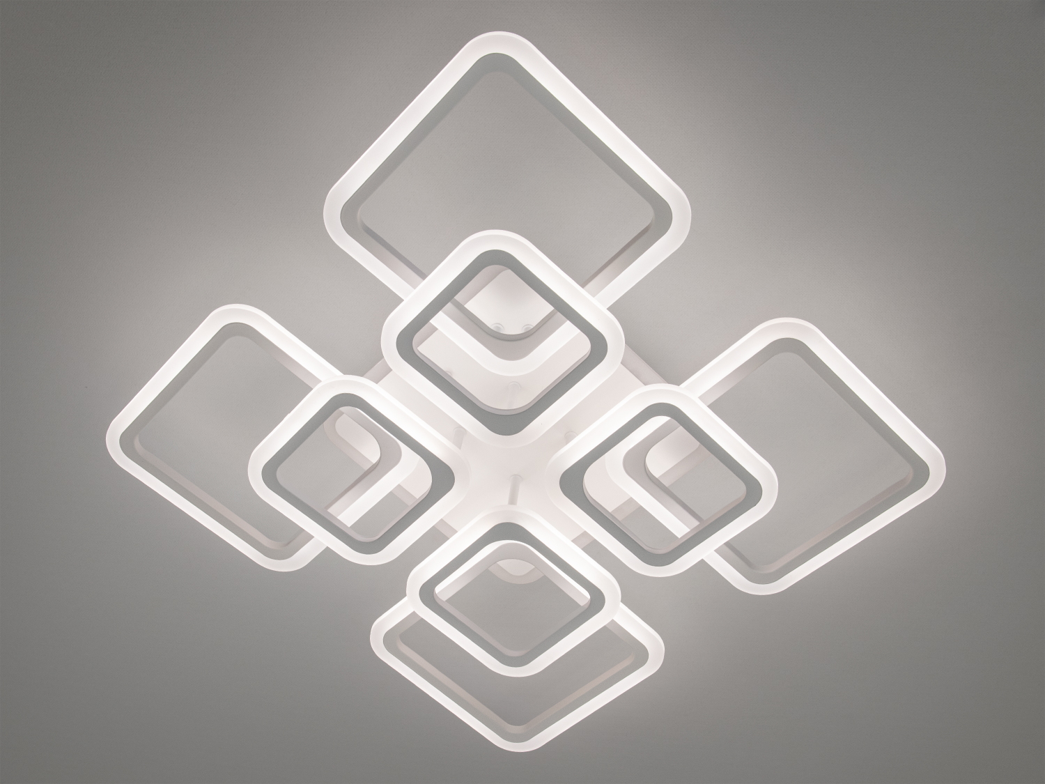 Яскрава LED-люстра у вітальню з підсвічуванням - це стильне та сучасне освітлювальне рішення, що поєднує в собі геометричну строгість та візуальну легкість. Її унікальна форма, що складається з восьми квадратних контурів, симетрично зібраних у вигляді динамічного хреста.