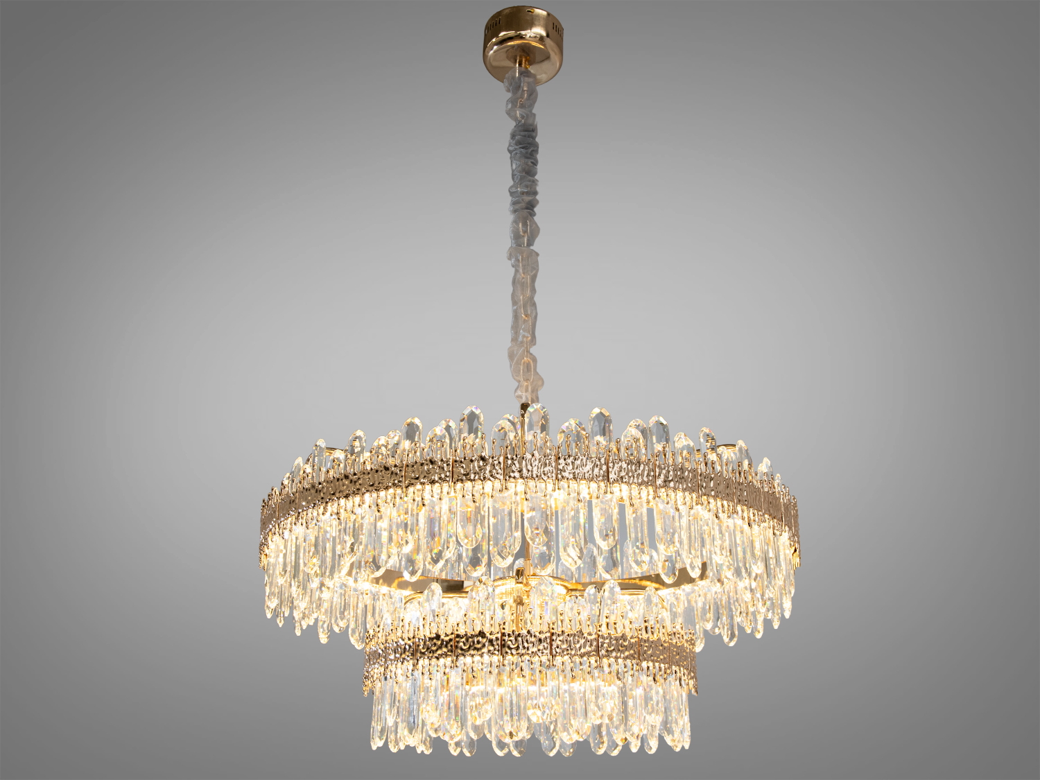 Аристократична кришталева LED люстра для вітальні також ідеально підійде для невеликих приміщень, і навіть для низьких стель, тому що висота регулюється, наприклад, у коридор, кухню, для зали або у вітальню в сучасному житловому комплексі або інтимніше оточення затишної спальні. У великих, відкритих просторах, таких як лобі готелю чи розкішному ресторані.
Світлодіодна люстра має кілька режимів: холодний 6000К, нейтральний 4100К, теплий 3200К. Перемикання здійснюється з настінного вимикача почерговим включенням/вимкненням. Світлодіоди дозволяють підбирати необхідну температуру світла. Використання гнучкого світлодіодного модуля в люстрі дозволяє вивести естетичні якості на новий сучасний рівень.
Розглядаючи цю люстру, слід відзначити переваги світлодіодного освітлення: воно енергоефективне, має великий термін служби та забезпечує відмінну якість світла.
Основа люстри, з її золотистим відливом, надає їй вигляду, який одночасно і класичний, і сучасний. Криштали, що рясно прикрашають люстру, мають однакові форми &mdash; довгі елегантні струмені, кожен з яких ідеально відшліфований для того, щоб ловити і відбивати світло від світлодіодних ламп.
Кріпиться до будь-яких стель (гіпсокартонним, навісним, натяжним) універсальним кріпленням-на планку.