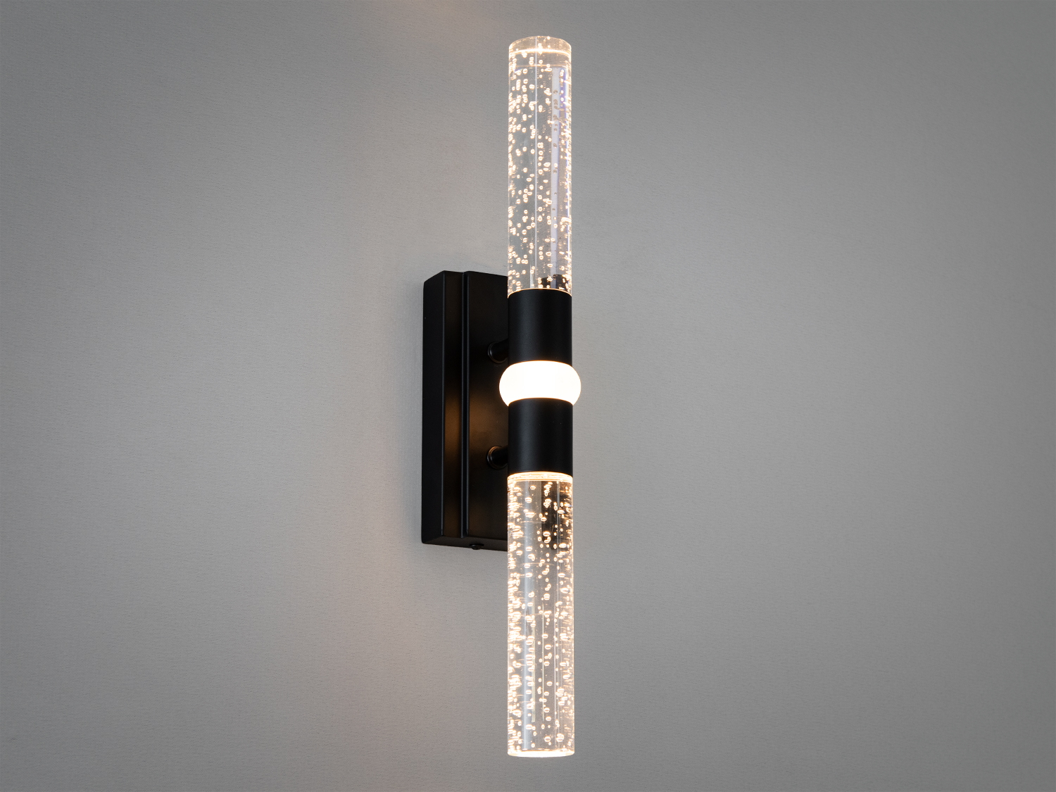 Витончений настінний LED світильник у вітальню - це сучасне рішення для освітлення, що поєднує стильний дизайн, функціональність та енергоефективність. Витончена мінімалістична форма із двома скляними циліндрами, закріпленими на міцній металевій основі, створює відчуття легкості та сучасності