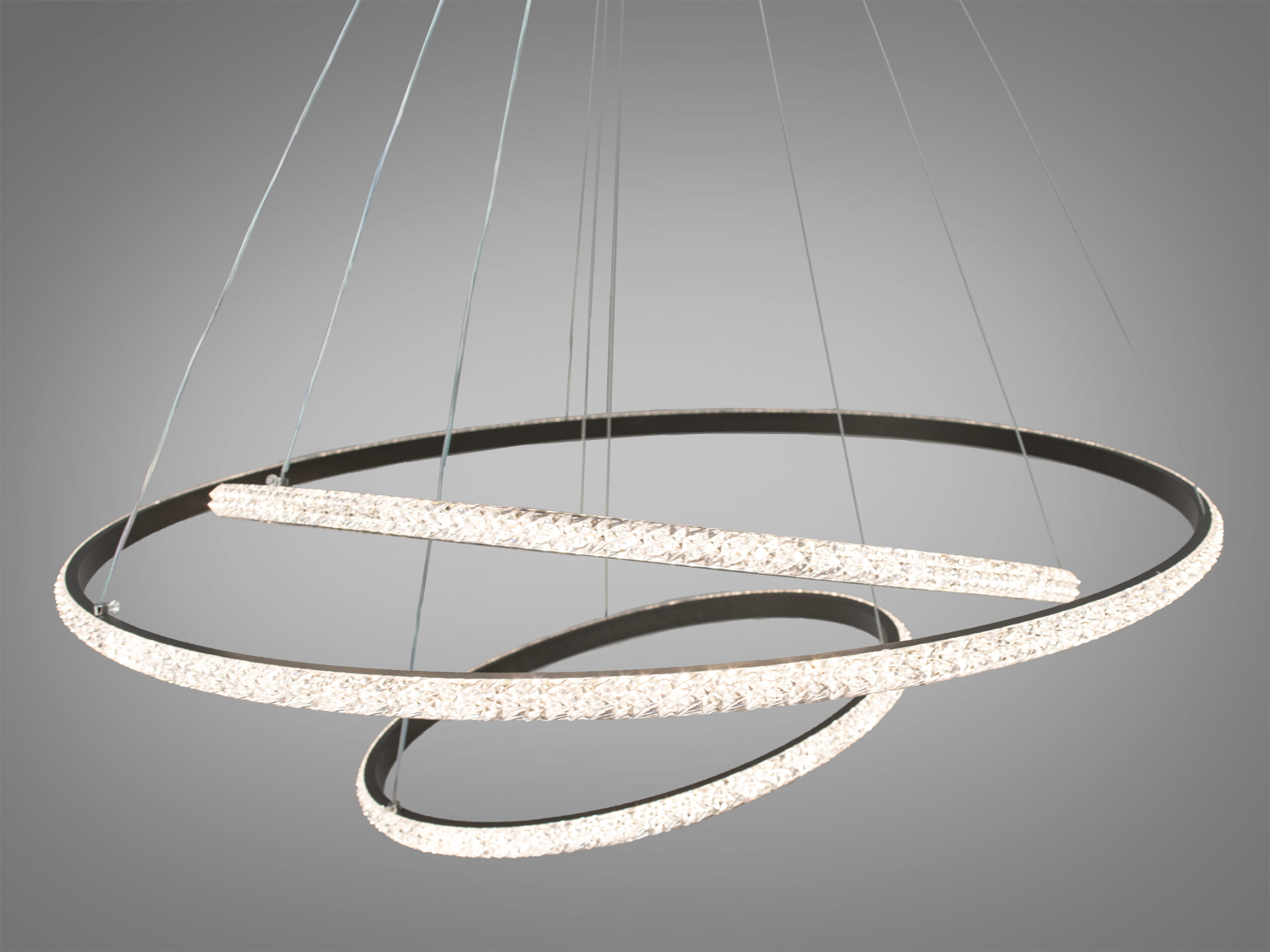 Світлодіодна люстра-підвіс &laquo;Кільця&raquo; укомплектовані диммером, що дозволяє відрегулювати яскравість від 5 до 100%, також можна вибрати режим освітлення &ndash; теплий, нейтральний чи холодний. За рахунок регулювання шнура можна підвісити кільця по-різному.
Кільця виконані з алюмінію з силіконовим розсіювачем. Алюміній ідеальний матеріал для світлодіодних люстр - не іржавіє, добре відводить тепло від світлодіодних модулів, хромування набагато міцніше зчіплюється з підставою ніж при анодуванні стали. Силіконовий розсіювач м'яко розсіює світло, приховуючи ефект світіння окремих світлодіодів. Створюється відчуття, що вся поверхня розсіювача світиться сама. При цьому на відміну від жорстких пластикових розсіювачів, такий неможливо зламати або розбити. Він не дряпає металеві елементи люстри. Не міняє колір навіть при температурах перевищують робочу в кілька разів. Все це забезпечить відмінний зовнішній вигляд люстри протягом багатьох років експлуатації.&nbsp;
Люстри-підвіси добре виглядають у вітальні та на кухнях.&nbsp;
Кріпиться до стель будь-якого типу універсальним кріпленням-на планку.