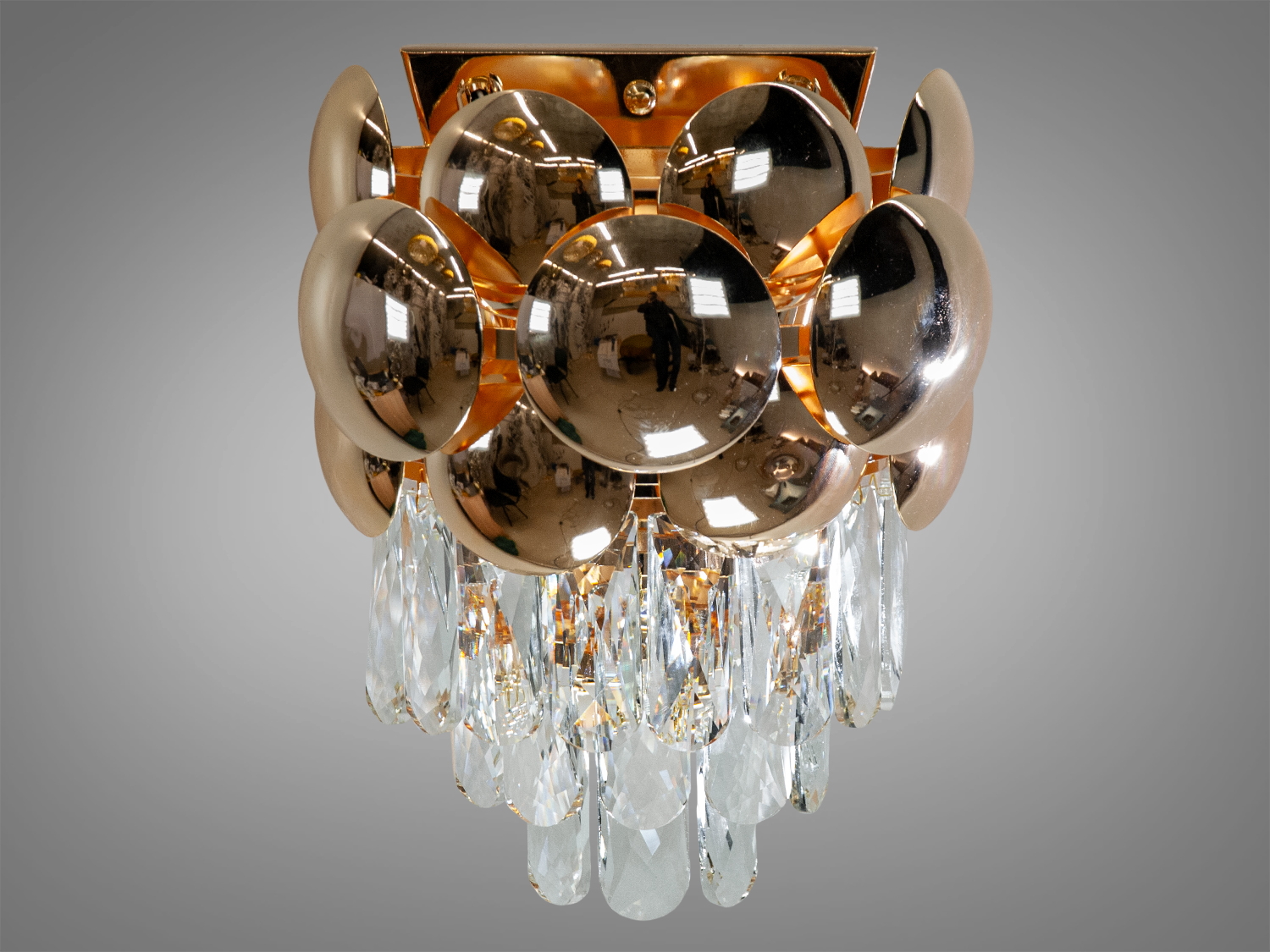 Класичний кришталевий світильник бра в сучасному стилі може бути використаний як окремий акцент створюючи гармонійне світлове середовище у вашому будинку. Він ідеально підійде як класичних інтер'єрів з розкішними деталями, так сучасних просторів, де шукають елементи дизайну з характером.
Використовуються високоякісні матеріали метал та кришталь. Світильник застосовується для сучасного стильного інтер'єру. У класичний інтер'єр вони вносять нотки сучасності, а квартирі студії в стилі лофт дарують крапельку суворості та впорядкованості. Нові настінні світильники виконані в класичному стилі та розраховані на 2 лампи з цоколем Е14.
З його металевою основою, блискучою як дзеркало, та рядами прозорих кришталів, світильник випромінює мерехтливе та іскрите світло, створюючи атмосферу елегантності та святковості. Кристали різного розміру, розташовані навколо лампочок цоколь Е14, немов танцюють у ритмі відблисків та променів, що виходять з їхнього центру.
Лампи до комплекту не входять.