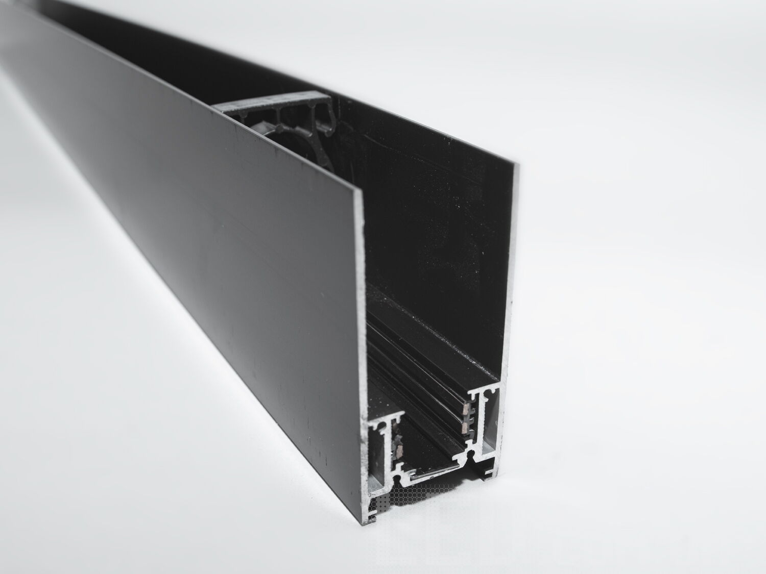 Рейлінг-шинопровід для магнітної трекової системи, підвісний/накладний.
Цей шинопровід має стильний прямокутний профіль із гладкою поверхнею, який гармонійно поєднується з будь-яким сучасним інтер&prime;єром. Його геометрія та зовнішній вигляд дозволяють застосовувати конструкцію як у підвісному, так і в накладному монтажі, відкриваючи широкі можливості для візуального та функціонального оформлення простору.
Така шина органічно інтегрується в архітектурні елементи інтер&prime;єру &mdash; стелі, стіни або інженерні коробки, не порушуючи естетики приміщення. Вона чудово підходить для відкритих стель у комерційних приміщеннях, шоурумах або житлових зонах, де важливо зберегти легкість і чистоту інтер&prime;єрних ліній.
Магнітна система кріплення світильників дозволяє швидко та без додаткових інструментів змінювати їхнє розташування, формуючи освітлення відповідно до змін у просторі або дизайні. Завдяки цьому шинопровід є ідеальним рішенням для адаптивних освітлювальних сценаріїв &mdash; від зосередженого робочого світла до м&rsquo;якої вечірньої атмосфери.
Всередині профілю інтегровано два електричних контуру &mdash; один забезпечує живлення підключених світильників, інший резервується для систем керування, таких як DALI або аналогічні. Це дозволяє використовувати інтелектуальні системи управління світлом і легко інтегрувати освітлення в єдину автоматизовану інфраструктуру.
Шинопровід підтримує живлення 48В &mdash; безпечну та оптимальну напругу для сучасних LED систем. Провідники прямокутного перерізу збільшують площу контакту, що гарантує стабільне електроживлення, а також довговічність та ефективність використання у професійних і побутових умовах.
Конструкція сумісна з трековими світильниками 35-ї та 20-ї серій, що дозволяє комбінувати компоненти в рамках єдиної системи освітлення. Це розширює можливості проектування освітлення, надаючи свободу архітекторам та дизайнерам у створенні освітлювальних концепцій.
Профіль сумісний із сучасними технологіями управління &mdash; включно з дистанційними контролерами, димерами, датчиками руху та автоматизацією розумного будинку. Такий підхід до проектування дає змогу створити повністю адаптивне середовище зі змінною світловою температурою, яскравістю та сценаріями увімкнення.
Підвісний або накладний монтаж не вимагає складних будівельних робіт, що робить цей шинопровід зручним для швидкого встановлення або модернізації вже існуючих приміщень. Особливо це актуально для офісів, торговельних залів, галерей, студій та квартир з відкритим плануванням.
Сучасний вигляд, надійна конструкція та багатофункціональність шинопроводу роблять його універсальним інструментом для реалізації ідей техно, мінімалістичних, лофт, скандинавських та hi-tech інтер&prime;єрів. Він гармонійно підкреслює простір і не перевантажує його візуально.
У результаті, рейлінг-шинопровід для магнітної трекової системи підвісного або накладного монтажу &mdash; це високотехнологічне рішення, що поєднує в собі зручність, адаптивність і сучасний дизайн, відкриваючи нові горизонти у створенні освітлення нового покоління.