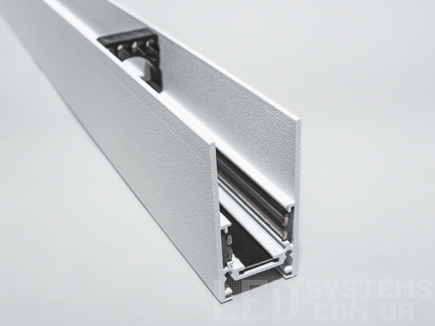 Рейлінг-шинопровід для магнітної трекової системи, підвісний/накладний.
Цей шинопровід має стильний прямокутний профіль із гладкою поверхнею, який гармонійно поєднується з будь-яким сучасним інтер′єром. Його геометрія та зовнішній вигляд дозволяють застосовувати конструкцію як у підвісному, так і в накладному монтажі, відкриваючи широкі можливості для візуального та функціонального оформлення простору.
Така шина органічно інтегрується в архітектурні елементи інтер′єру &mdash; стелі, стіни або інженерні коробки, не порушуючи естетики приміщення. Вона чудово підходить для відкритих стель у комерційних приміщеннях, шоурумах або житлових зонах, де важливо зберегти легкість і чистоту інтер′єрних ліній.
Магнітна система кріплення світильників дозволяє швидко та без додаткових інструментів змінювати їхнє розташування, формуючи освітлення відповідно до змін у просторі або дизайні. Завдяки цьому шинопровід є ідеальним рішенням для адаптивних освітлювальних сценаріїв &mdash; від зосередженого робочого світла до м&rsquo;якої вечірньої атмосфери.
Всередині профілю інтегровано два електричних контуру &mdash; один забезпечує живлення підключених світильників, інший резервується для систем керування, таких як DALI або аналогічні. Це дозволяє використовувати інтелектуальні системи управління світлом і легко інтегрувати освітлення в єдину автоматизовану інфраструктуру.
Шинопровід підтримує живлення 48В &mdash; безпечну та оптимальну напругу для сучасних LED систем. Провідники прямокутного перерізу збільшують площу контакту, що гарантує стабільне електроживлення, а також довговічність та ефективність використання у професійних і побутових умовах.
Конструкція сумісна з трековими світильниками 20-ї серій, що дозволяє комбінувати компоненти в рамках єдиної системи освітлення. Це розширює можливості проектування освітлення, надаючи свободу архітекторам та дизайнерам у створенні освітлювальних концепцій.
Профіль сумісний із сучасними технологіями управління &mdash; включно з дистанційними контролерами, димерами, датчиками руху та автоматизацією розумного будинку. Такий підхід до проектування дає змогу створити повністю адаптивне середовище зі змінною світловою температурою, яскравістю та сценаріями увімкнення.
Підвісний або накладний монтаж не вимагає складних будівельних робіт, що робить цей шинопровід зручним для швидкого встановлення або модернізації вже існуючих приміщень. Особливо це актуально для офісів, торговельних залів, галерей, студій та квартир з відкритим плануванням.
Сучасний вигляд, надійна конструкція та багатофункціональність шинопроводу роблять його універсальним інструментом для реалізації ідей техно, мінімалістичних, лофт, скандинавських та hi-tech інтер′єрів. Він гармонійно підкреслює простір і не перевантажує його візуально.
У результаті, рейлінг-шинопровід для магнітної трекової системи підвісного або накладного монтажу &mdash; це високотехнологічне рішення, що поєднує в собі зручність, адаптивність і сучасний дизайн, відкриваючи нові горизонти у створенні освітлення нового покоління.